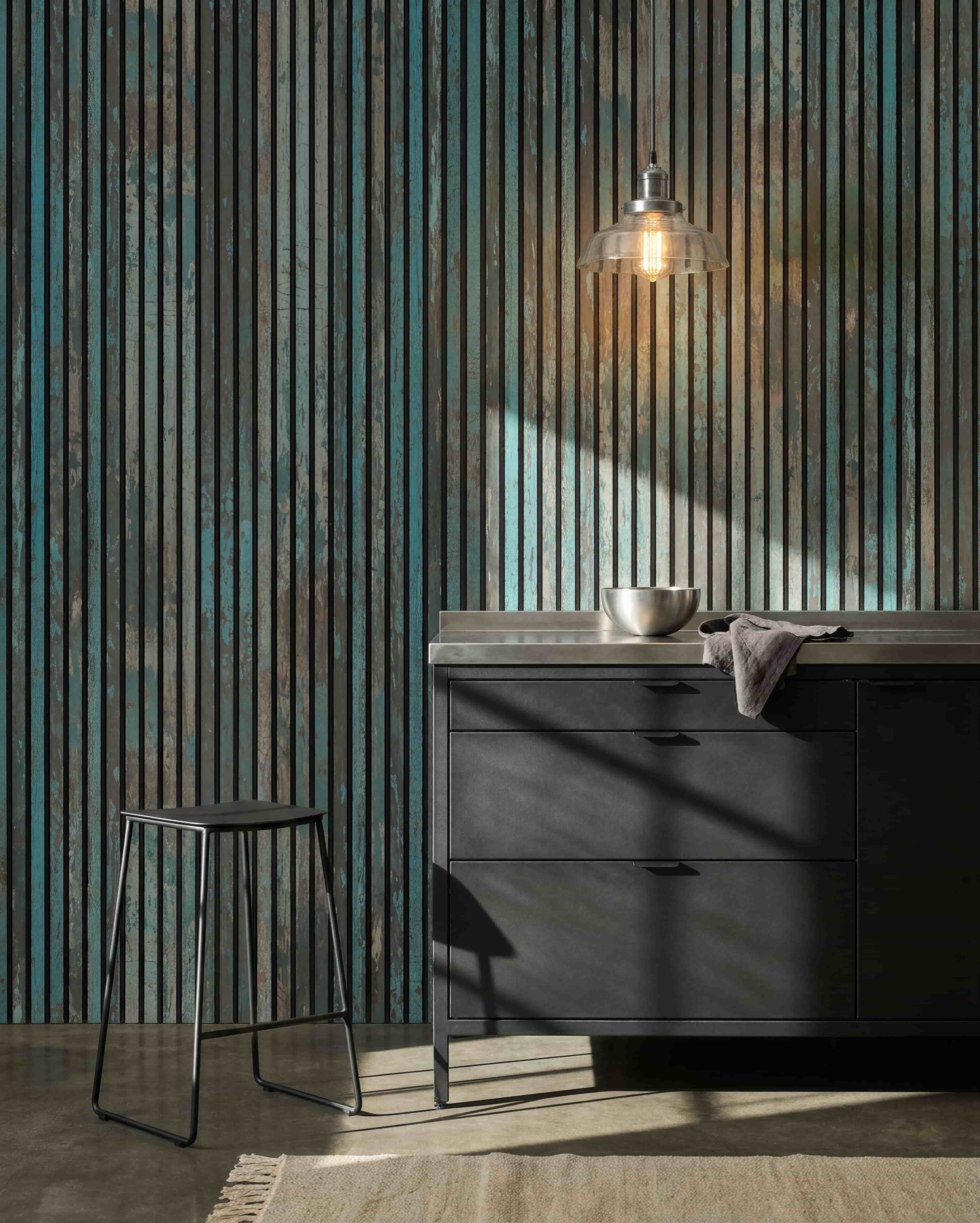Cozinha moderna com bancos black, armários black, uma taça sob uma luz suspensa e um Painel acústico WoodUpp Akupanel Azul Óxido na parede para maior conforto acústico.