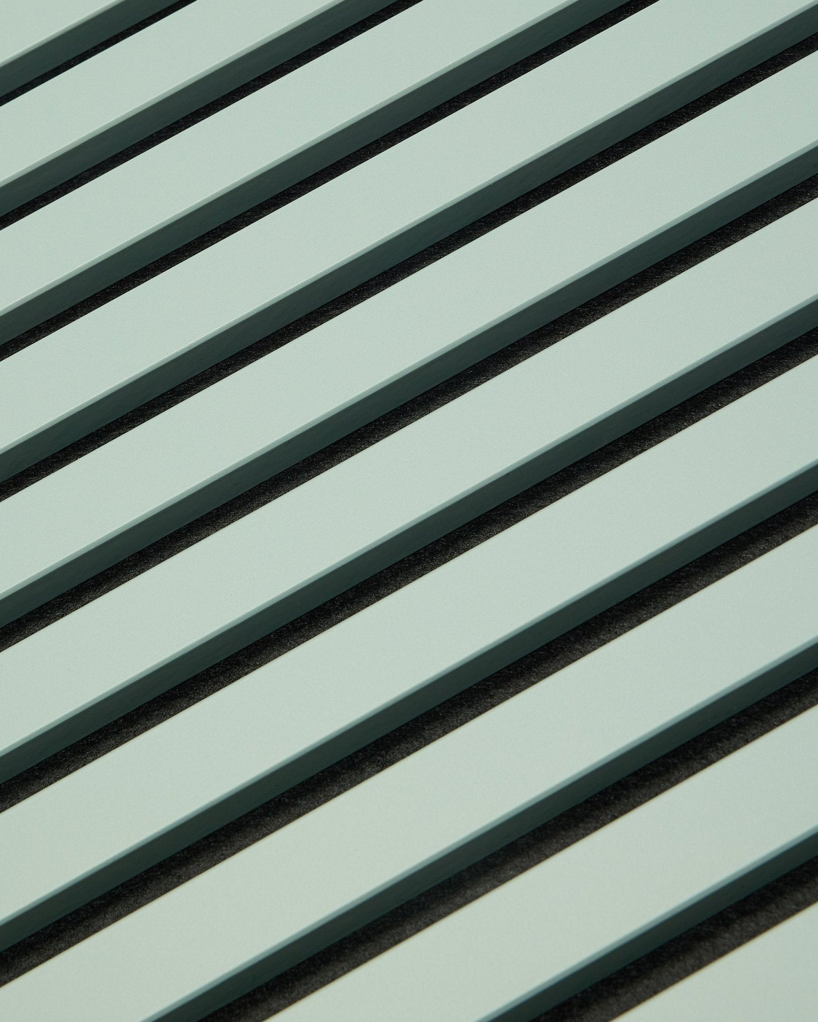 Hue | Akupanel / Cloud da WoodUpp apresenta painéis acústicos de madeira em verde-claro com ripas vertical e espaços escuros, criando um padrão geométrico para absorção sonora.