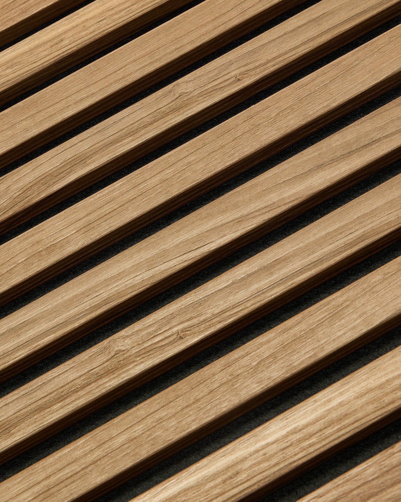 Close-up diagonal do WoodUpp Akupanel Essential Painel acústico em English Walnut, 240x60 cm, mostrando um acabamento uniforme e fundo escuro entre cada ripa de madeira.