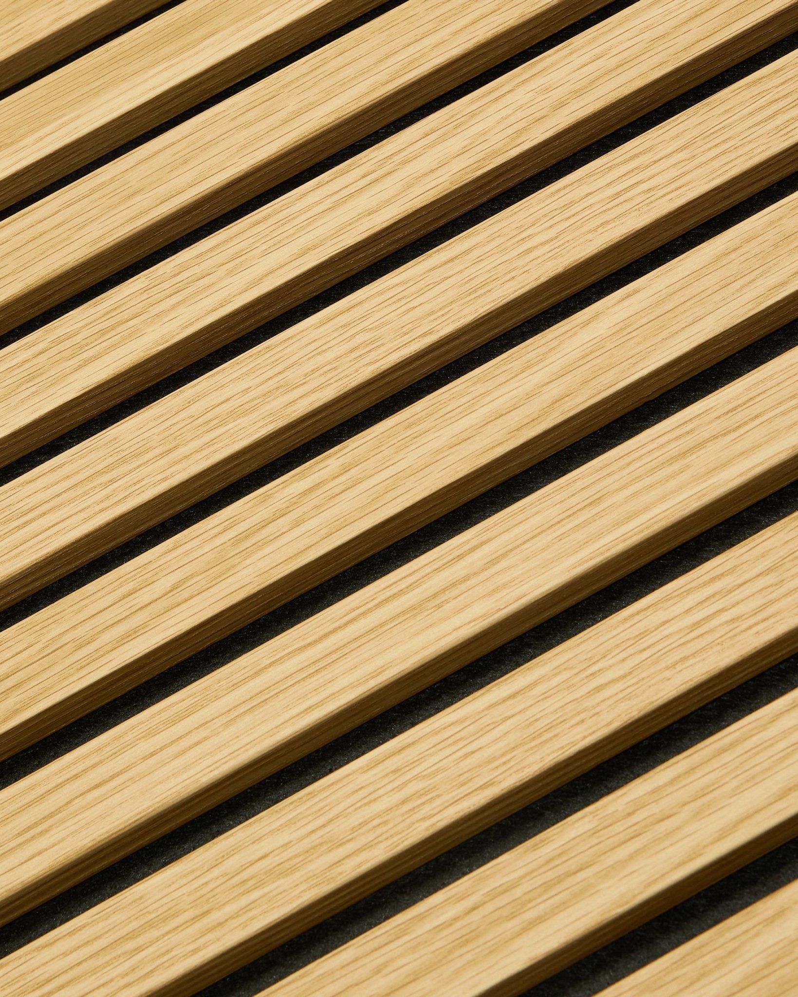 Plano aproximado do painel WoodUpp Akupanel Painel acústico em Carvalho Southern Oak, 240x60 cm, com ripas diagonais e espaços acústicos escuros para uma melhor absorção sonora.