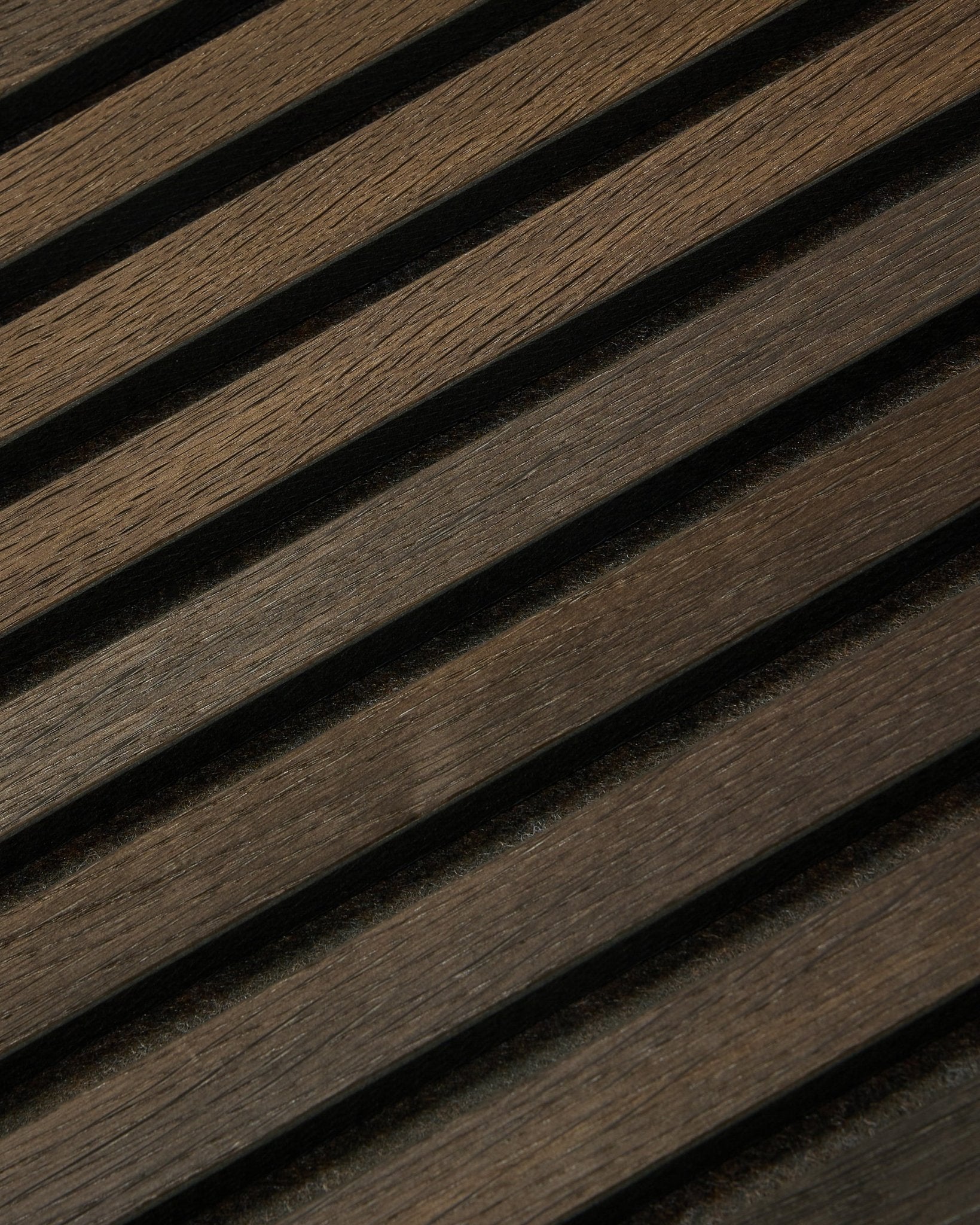 Plano aproximado do Tonal Akupanel Painel acústico em Smoked Oak (240 x 60 cm) da WoodUpp, com ripas nórdicas diagonais texturadas num design escandinavo.
