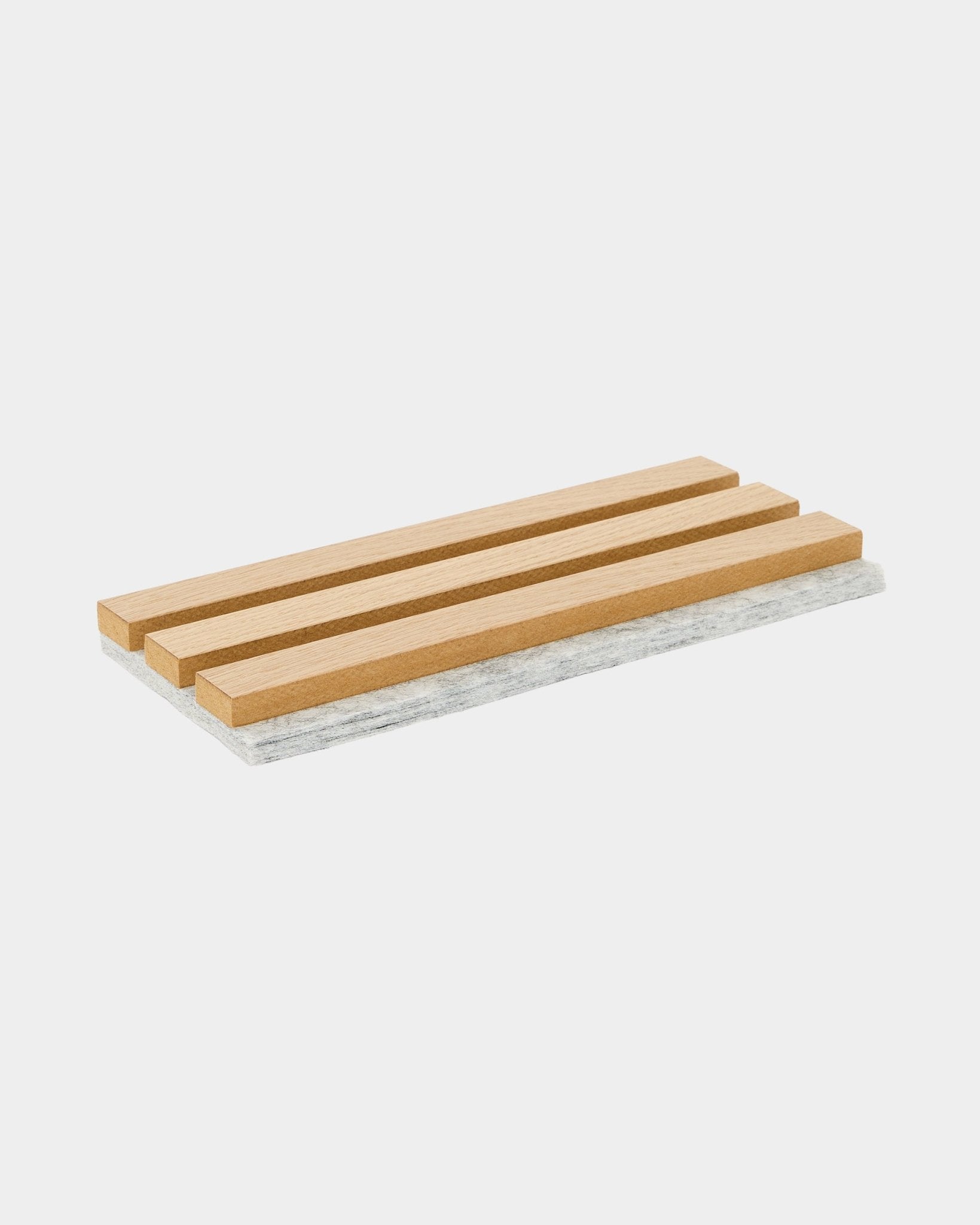 Base para panelas de amostra WoodUpp Akupanel com ripas clássicas em carvalho e verso em feltro cinzento, pensada para proteger superfícies e mostrar o material acústico nórdico.