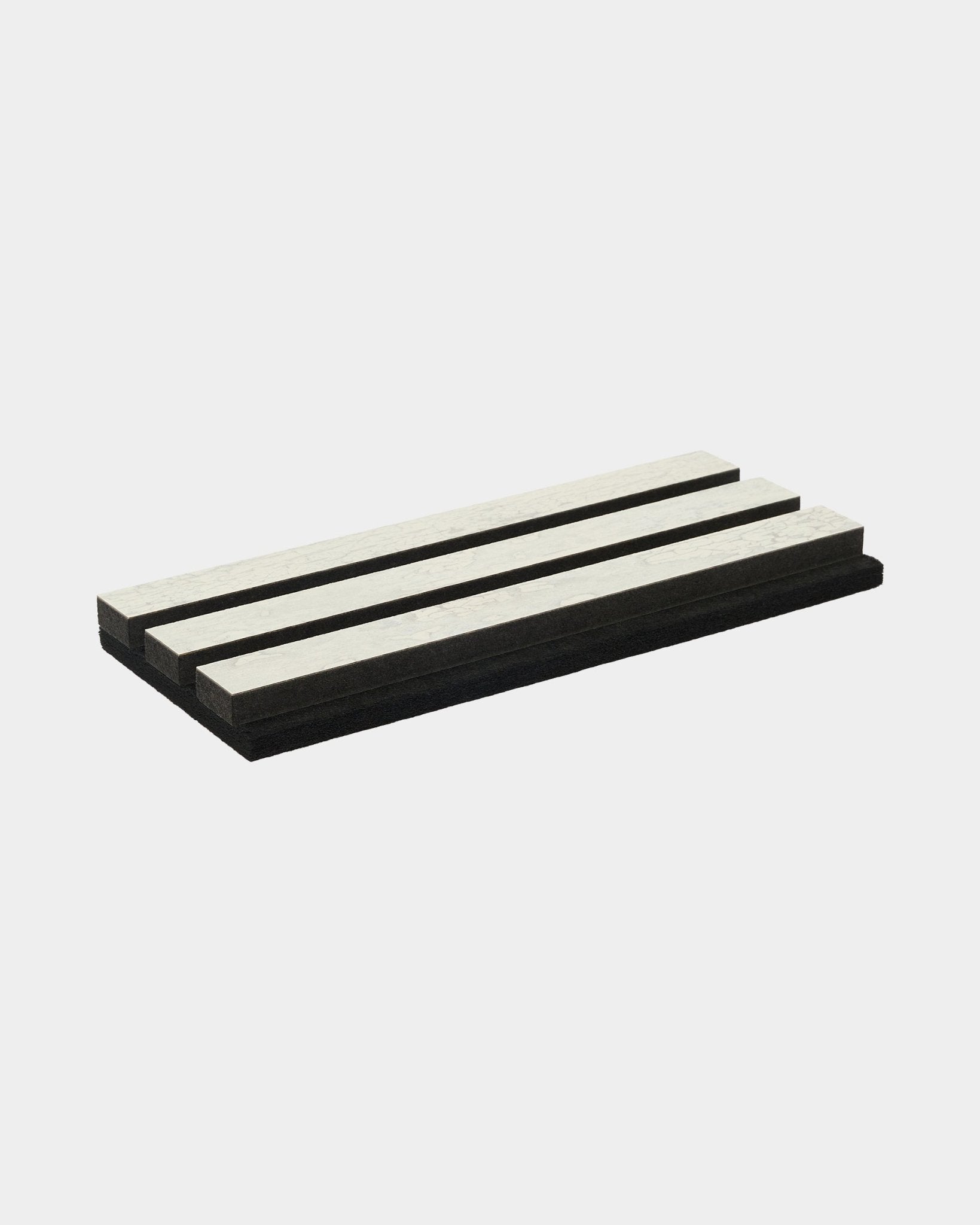 A tábua de corte de amostra Rebel da WoodUpp, apresentada no acabamento White Oxide com black e riscas brancas, reflete a estética nórdica minimalista da marca.