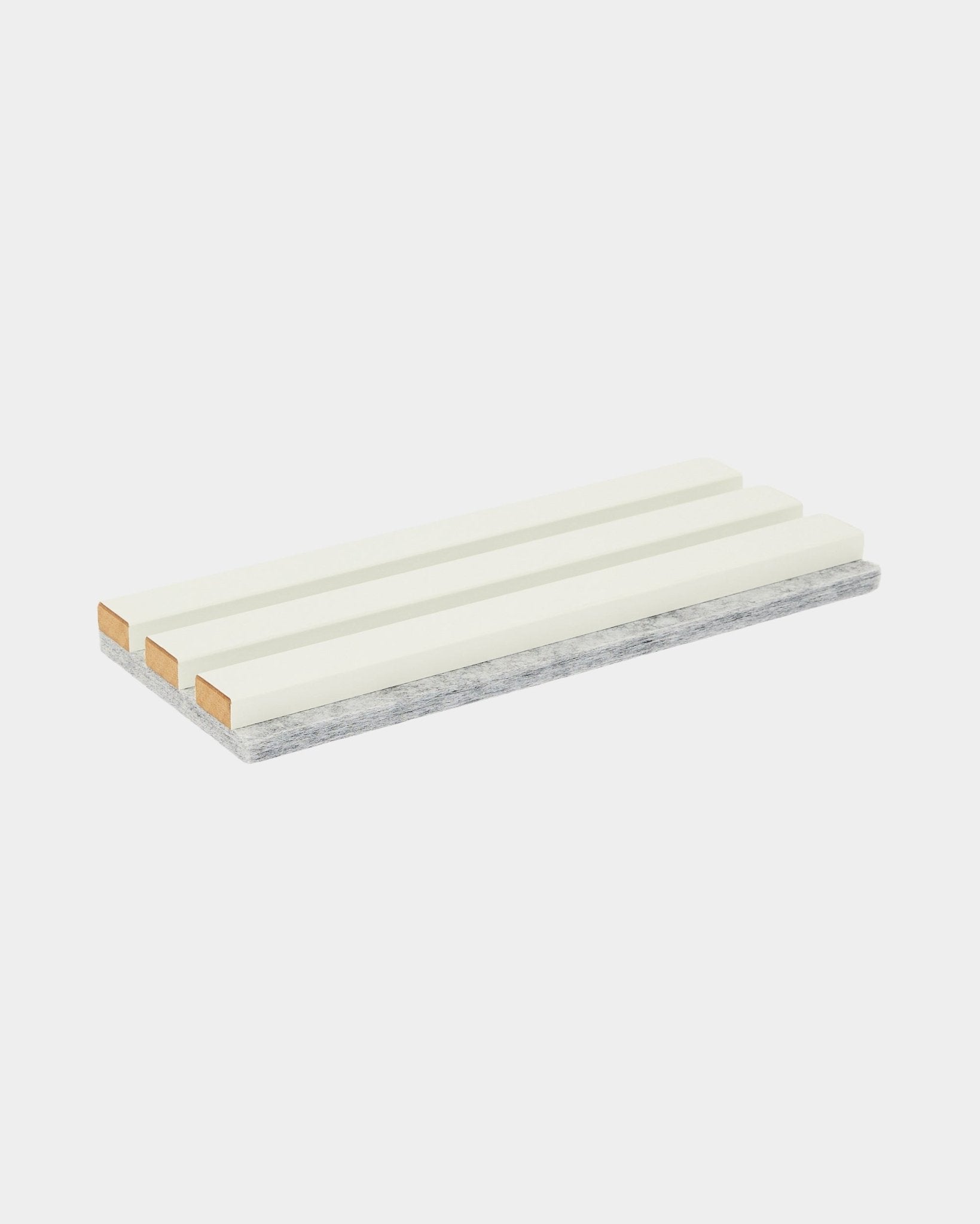 A amostra Hue / Snow da WoodUpp é uma esponja de limpeza retangular com três faixas brancas e uma camada cinzenta resistente para esfregar, usada para a manutenção de Painel acústico.