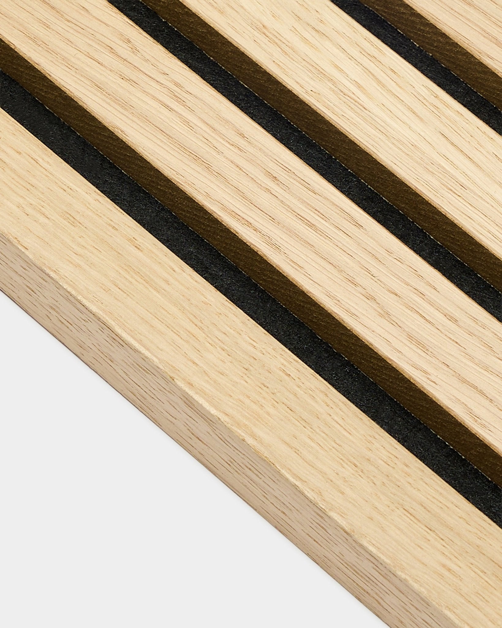 Grande plano da lamela terminal WoodUpp Akupanel em Carvalho Clássico, com 2,2 cm de espessura, mostrando riscas paralelas black e brown, características dos painéis acústicos nórdicos.