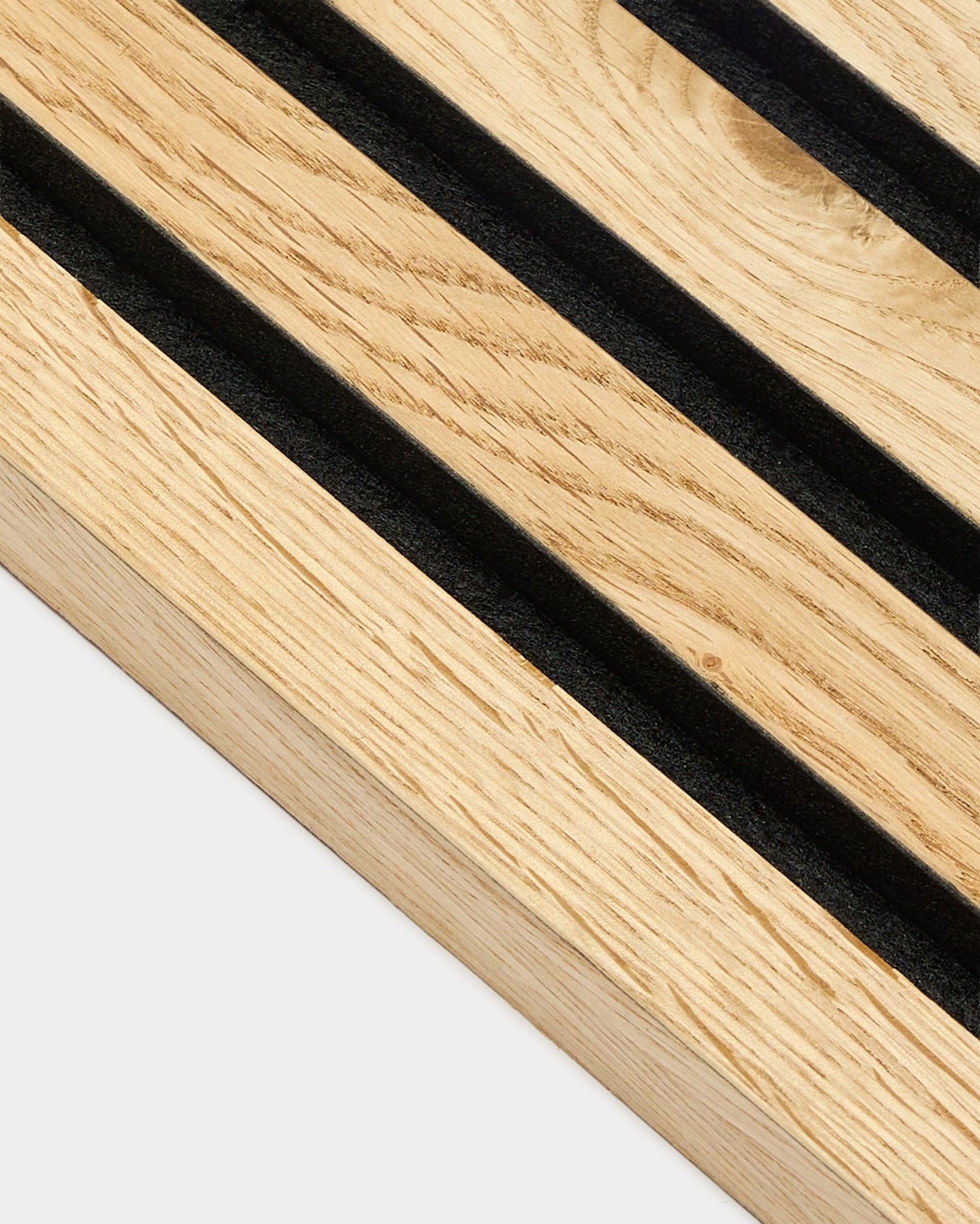 Grande plano da lamela de extremidade WoodUpp Akupanel em natural oak rústico, com 2,2 cm de espessura, com ranhuras diagonais em black e textura de veio natural wood visível.