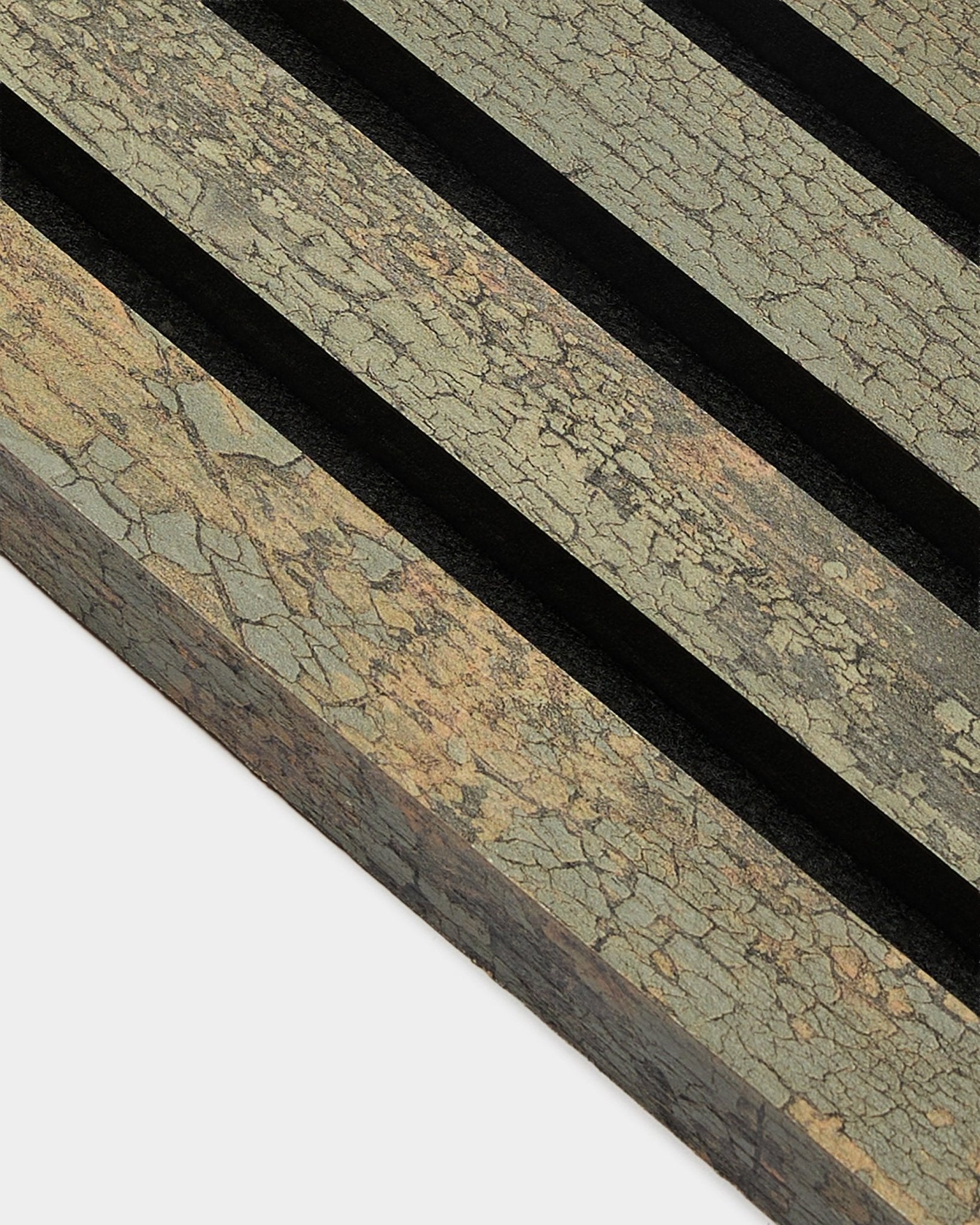 Grande plano da lamela de extremidade WoodUpp Akupanel em Óxido Grey, 2,2 cm, mostrando Painel acústico texturado com ranhuras black numa superfície em tons terrosos.