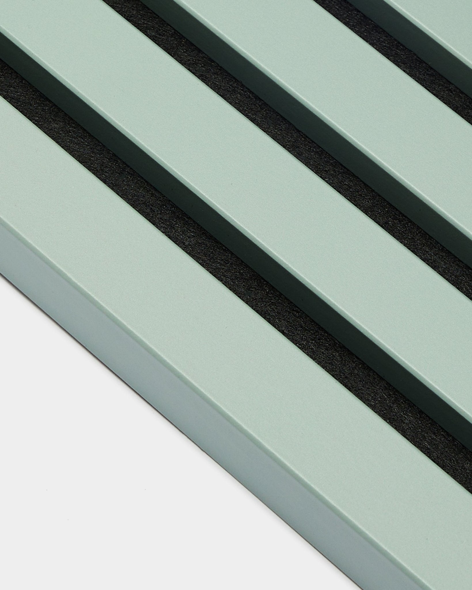Grande plano de três ripas End Lamella / Cloud verde-pastel paralelas, com 2,2 cm de largura, da WoodUpp, como parte de um(a) Akupanel Painel acústico sobre um fundo claro.
