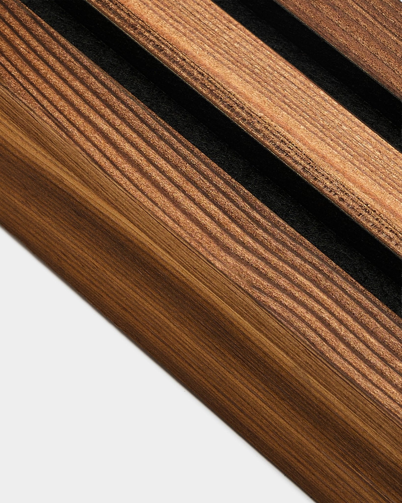 Vista detalhada da lamela terminal WoodUpp em Rustic Smoked Larch, 6,7 cm, concebida para o acabamento de extremidades de Akupanel Painel acústico em paredes de cor clara-colored.