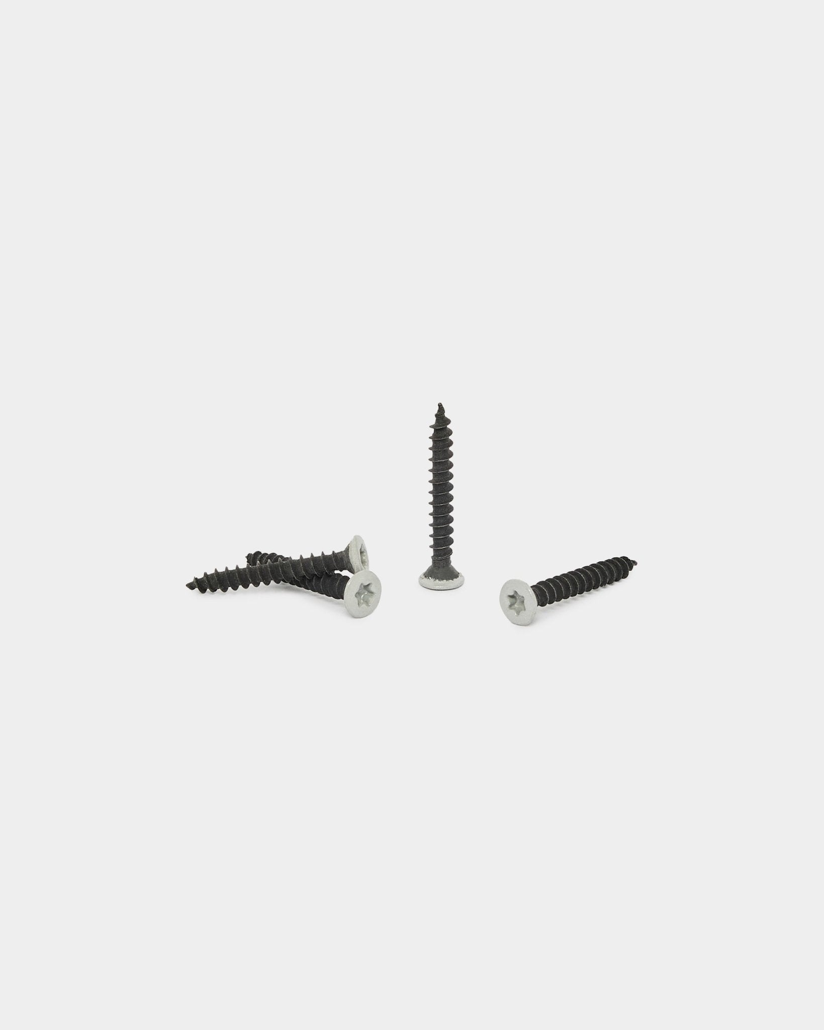 Quatro parafusos WoodUpp grey do conjunto de produtos de instalação (100 peças), apresentados sobre um fundo branco liso; três estão horizontal e um está na vertical.