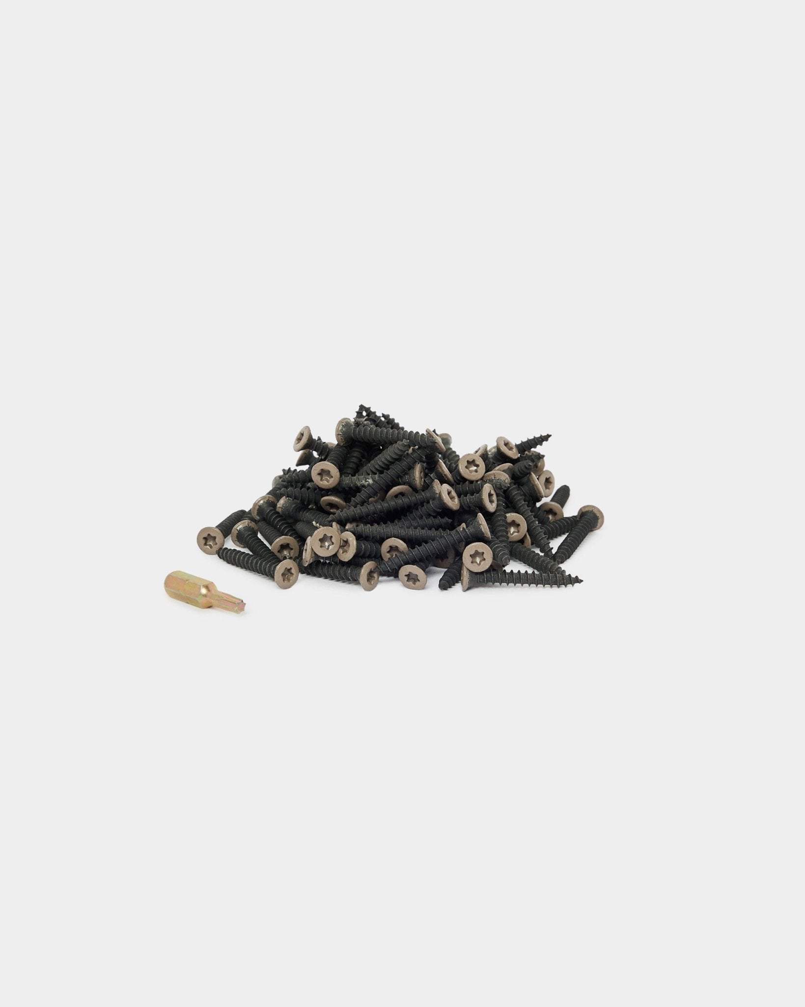 Parafusos de instalação WoodUpp Warm Grey (100 un.) e uma ponta de aparafusadora dourada dispostos sobre um fundo branco, adequados para a instalação de Painel acústico ou de acessórios de painéis.