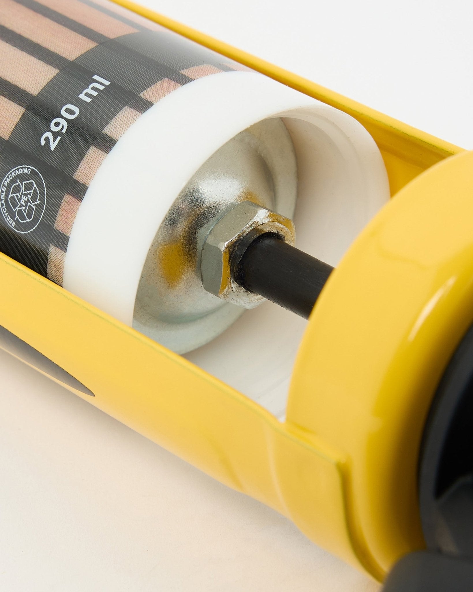 Vista detalhada da WoodUpp Grout Gun (290 ml), uma ferramenta de instalação amarela com componentes metálicos usada para montar painéis acústicos e divisórias de espaço.