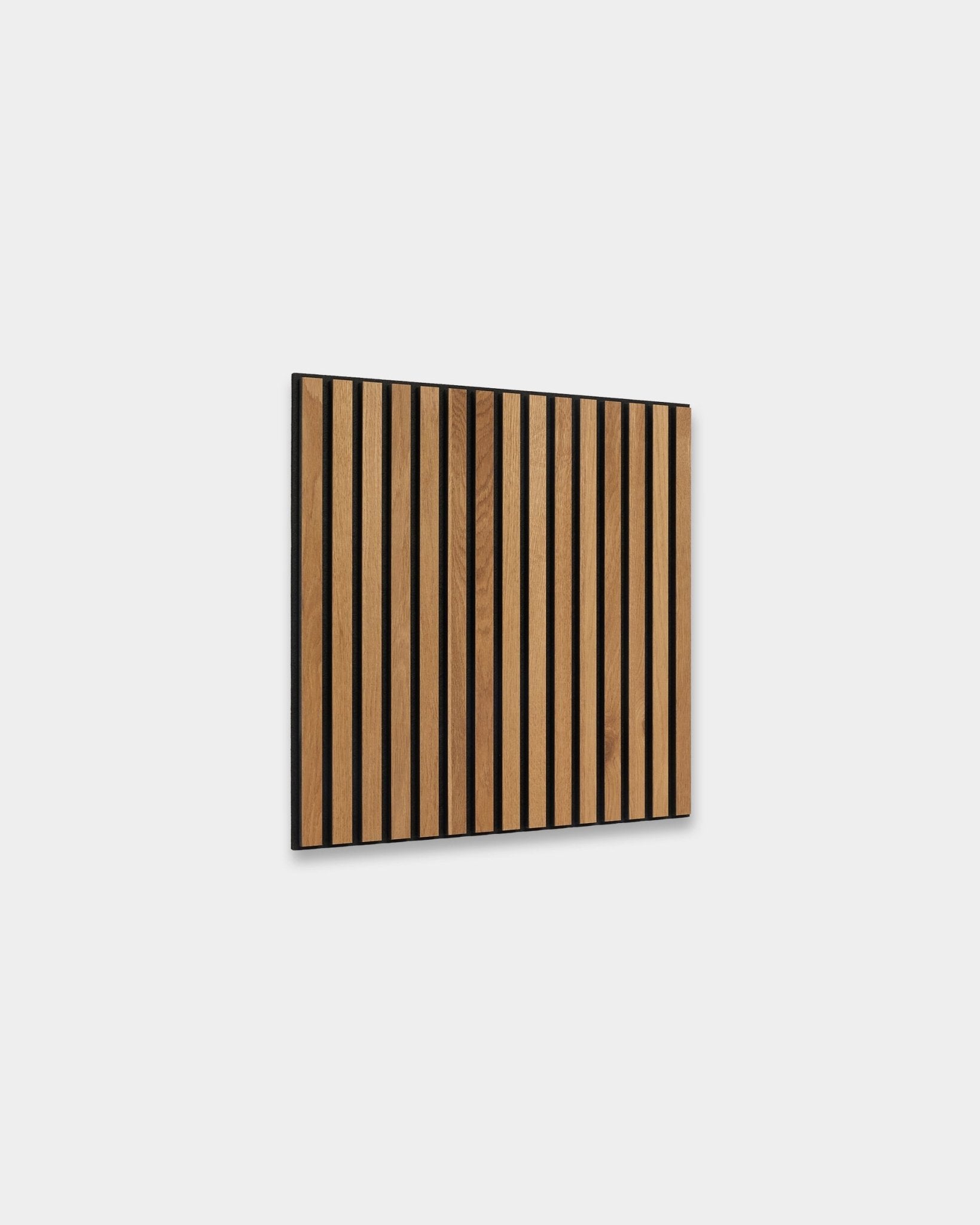 WoodUpp Akupixel Rustic Brown Oak 60x60cm Painel acústico com ripas de vertical e espaçamentos de black, apresentado contra uma parede interior nórdica cinzento-claro.
