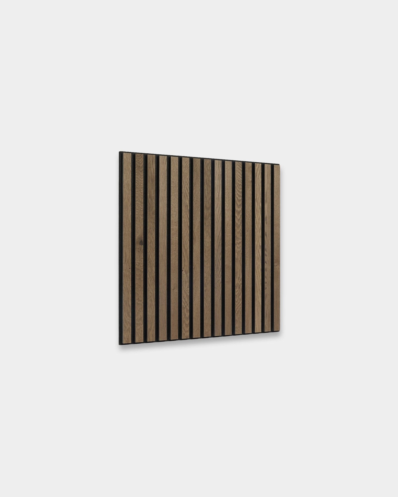 WoodUpp Akupixel Painel acústico em grey oak, 60x60 cm, com ripas escuras em brown vertical ao estilo escandinavo, numa parede cinzento-claro.