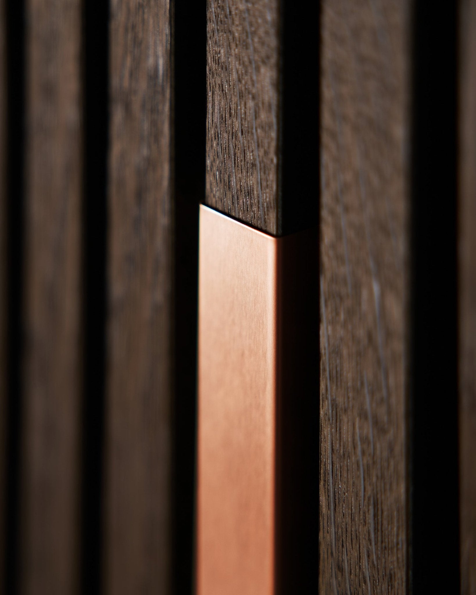 Plano aproximado de WoodUpp Akupanel Liva | Cover em Copper, 60 cm, mostrando ripas acústicas em madeira vertical com apontamento em copper para dar textura e contraste.