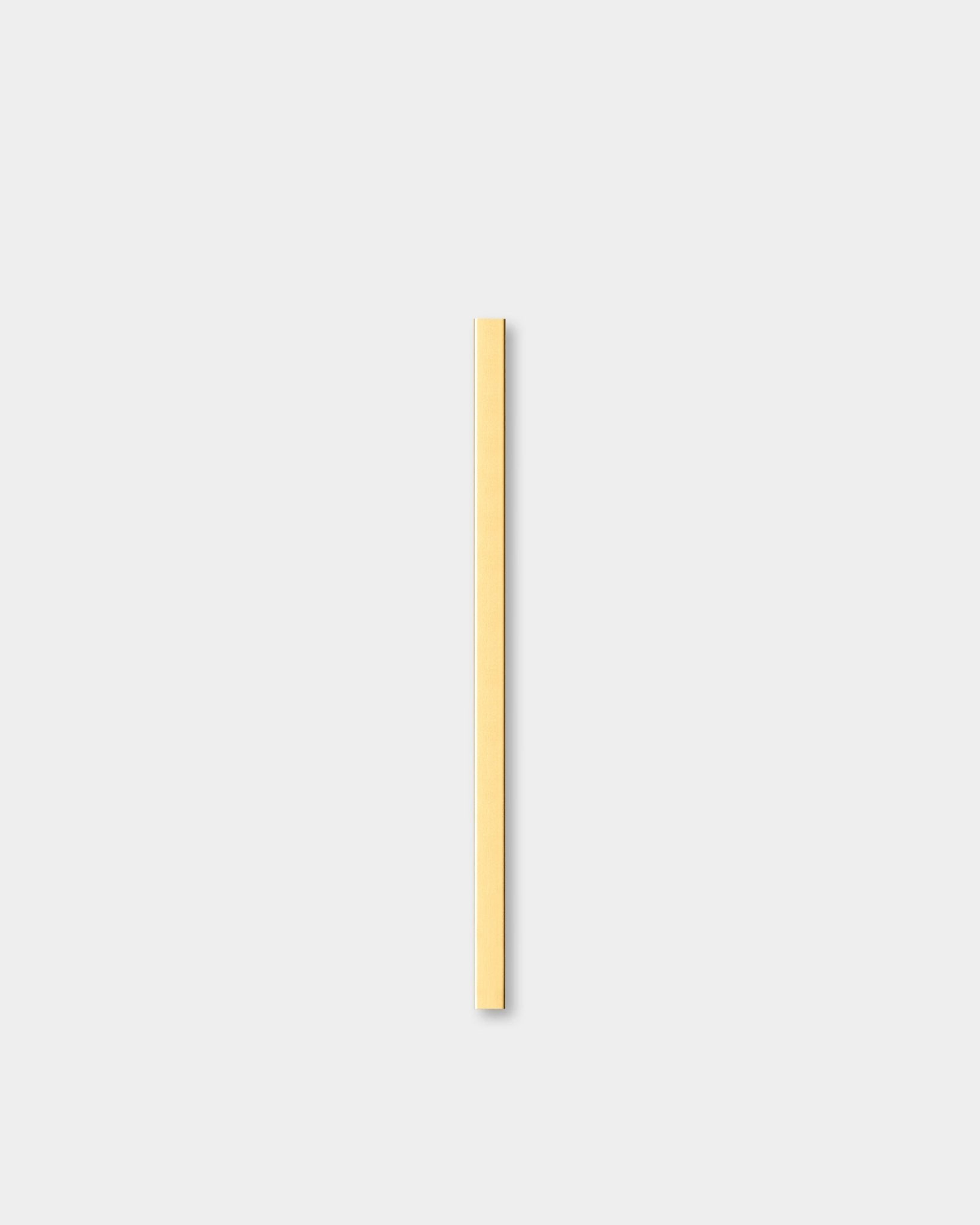 O/A Liva | Cover em brass, 60 cm, da WoodUpp, um(a) Painel acústico, está colocado(a) na vertical contra um fundo cinzento-claro, ao lado de uma moldura decorativa de parede.