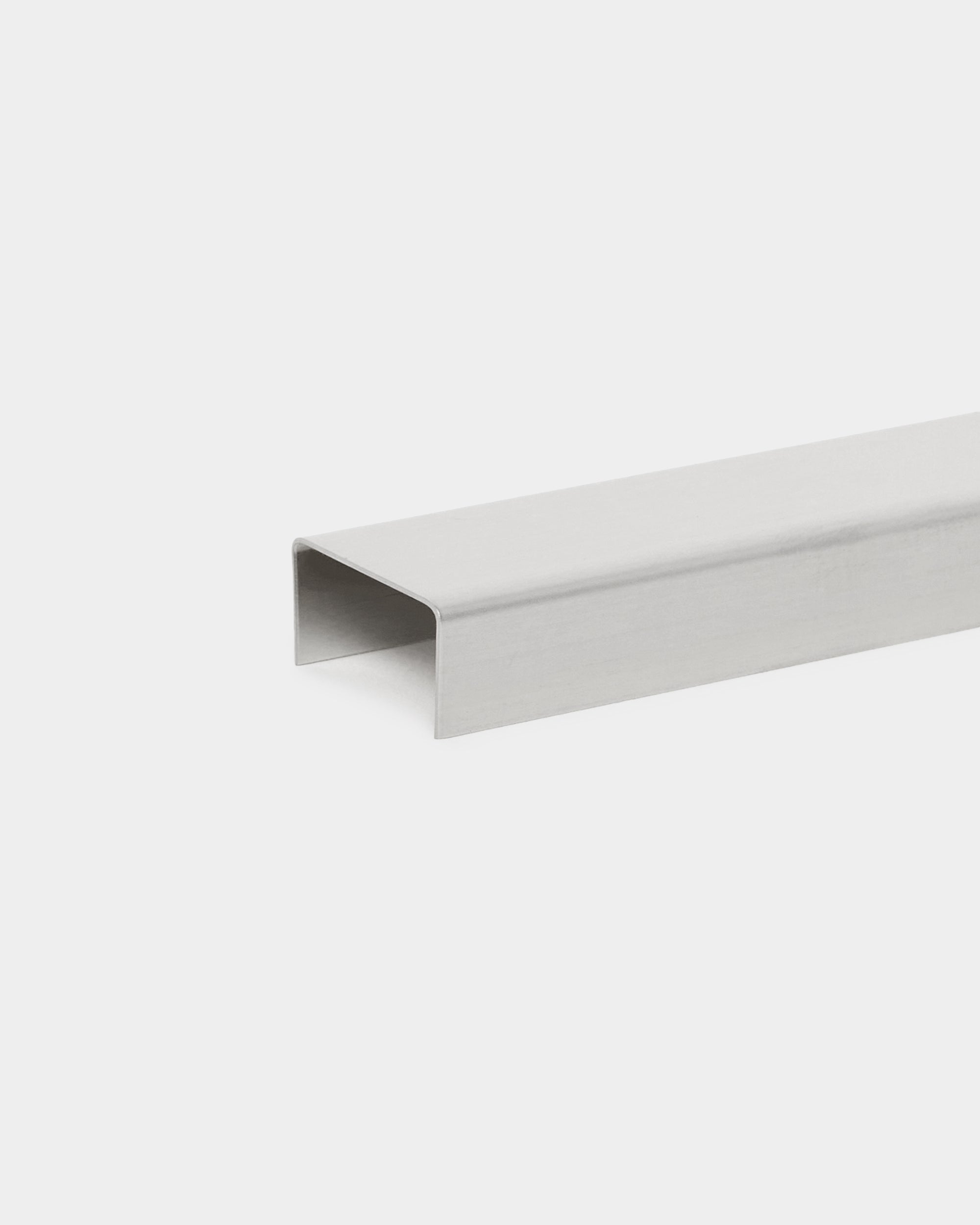 Liva Cover da WoodUpp: acessório de canal metálico em U de 60 cm, em steel polido, concebido para ser usado com painéis acústicos Akupanel, apresentado sobre fundo branco.