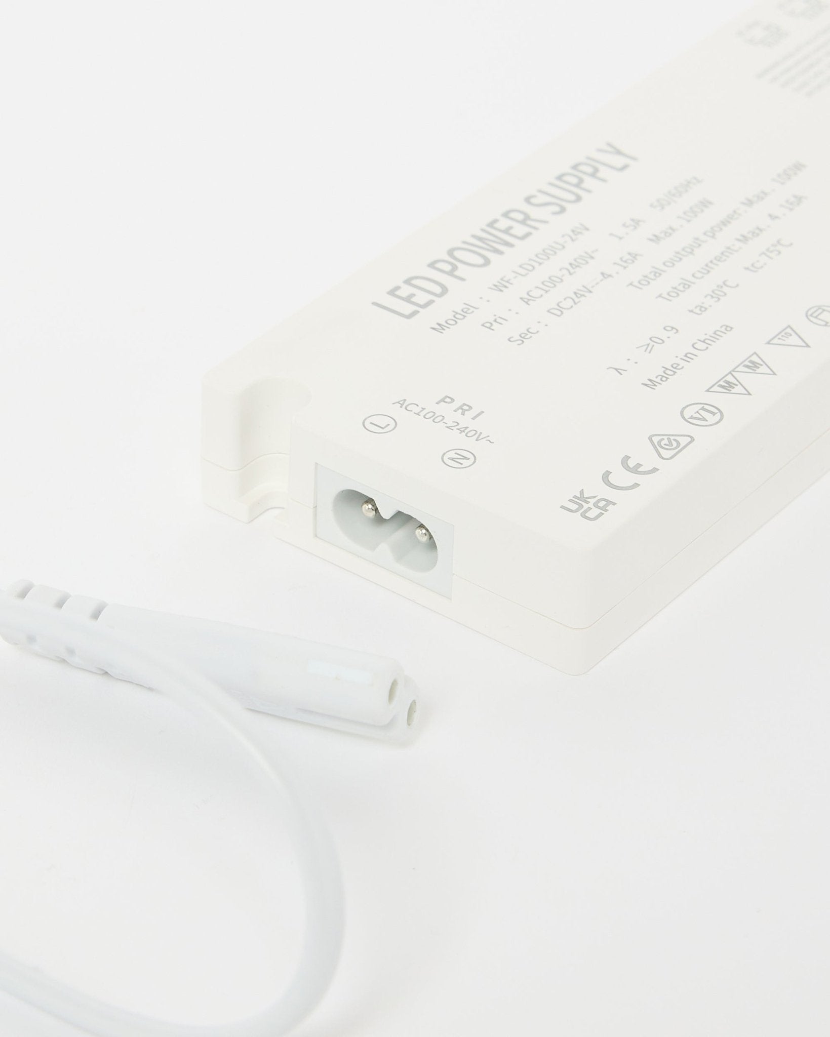 Grande plano de uma fonte de alimentação para fitas LED WoodUpp beige Lumi (240 cm), com detalhes técnicos visíveis e um cabo ao lado, concebida para instalações nórdicas Painel acústico.
