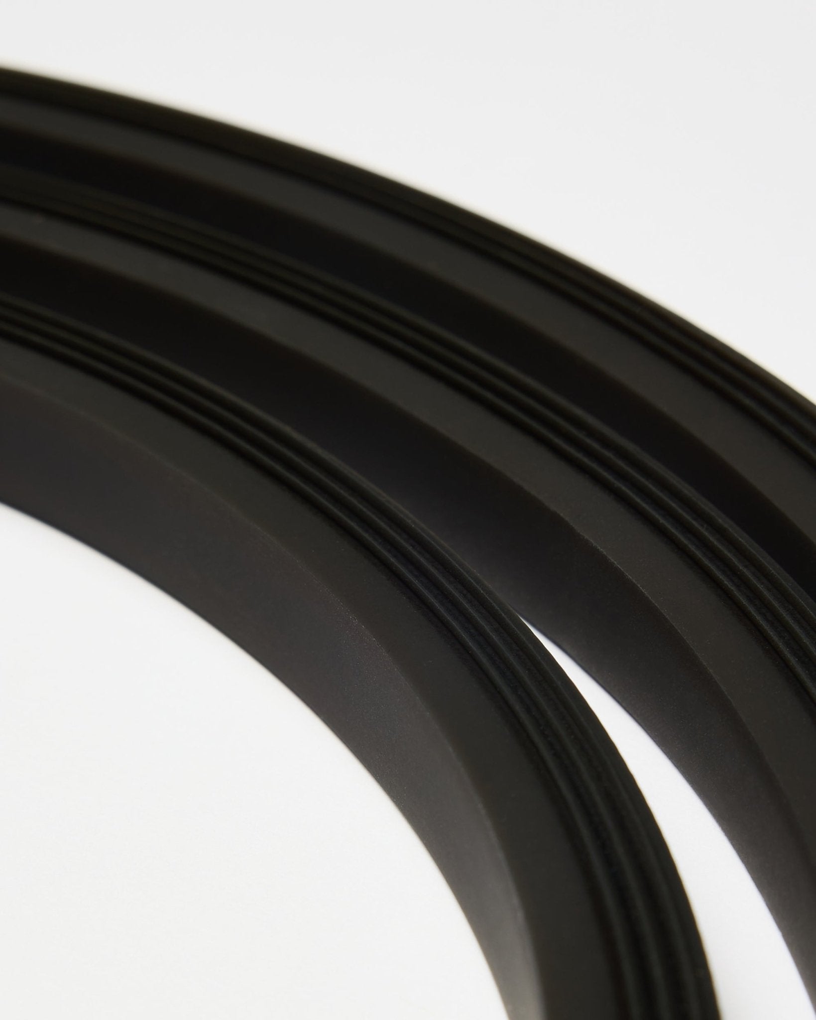 Plano aproximado da fita LED Lumi black da WoodUpp (300 cm), disposta em linhas curvas sobre fundo branco, a complementar o estilo minimalista Akupanel Painel acústico.