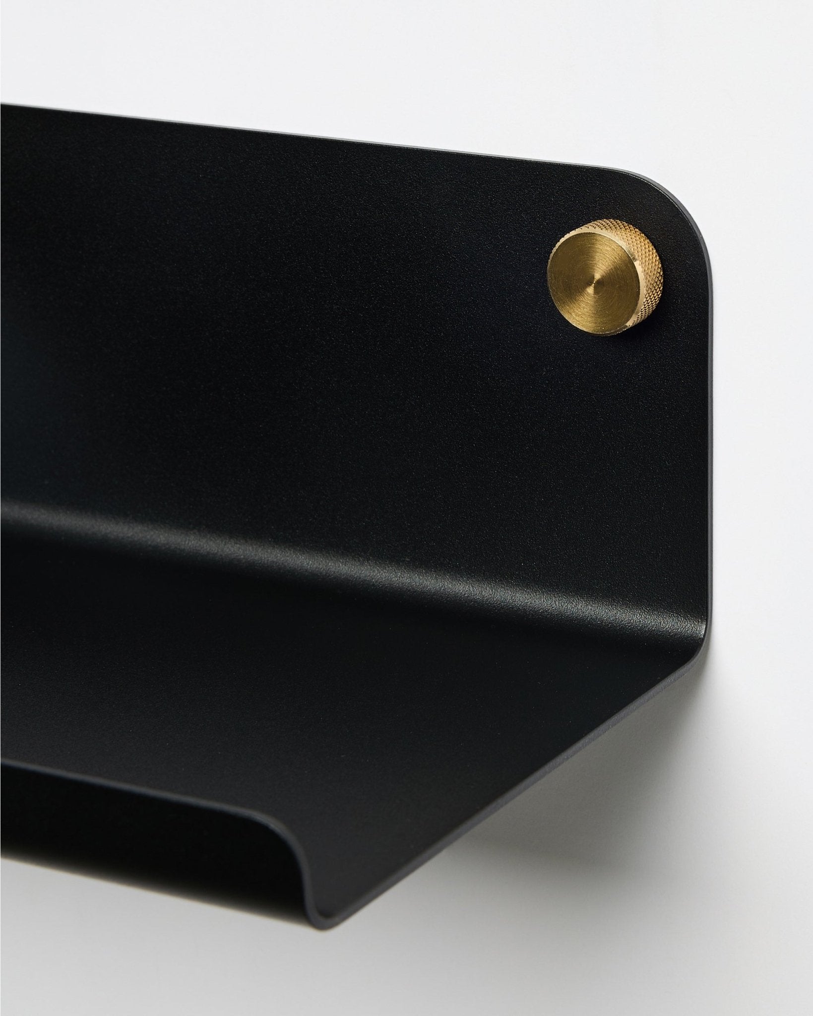 Plano aproximado da prateleira larga WoodUpp Norr em black, 35,9 cm, com bordo curvo, fixada à parede com um parafuso redondo brass. Design nórdico minimalista.