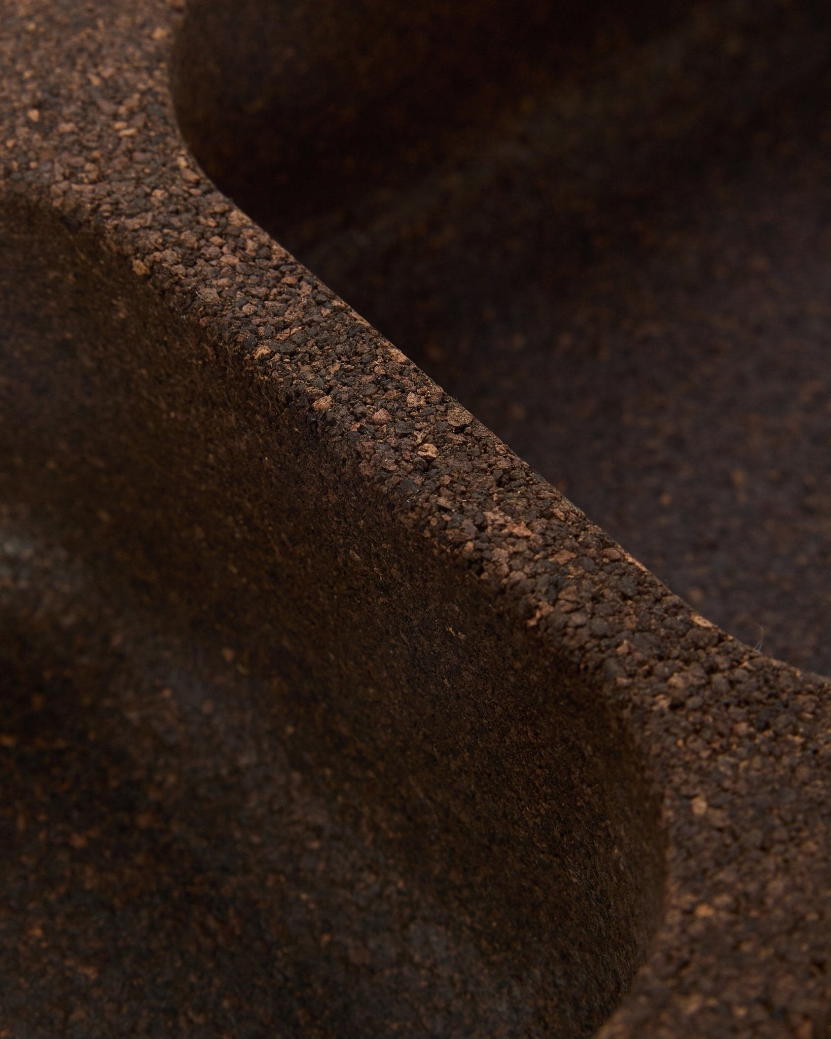 Plano aproximado do acessório WoodUpp Norr Key Tray em cortiça fumada (35,9 cm), mostrando uma superfície brown texturada com relevos suaves e curvos e design nórdico.