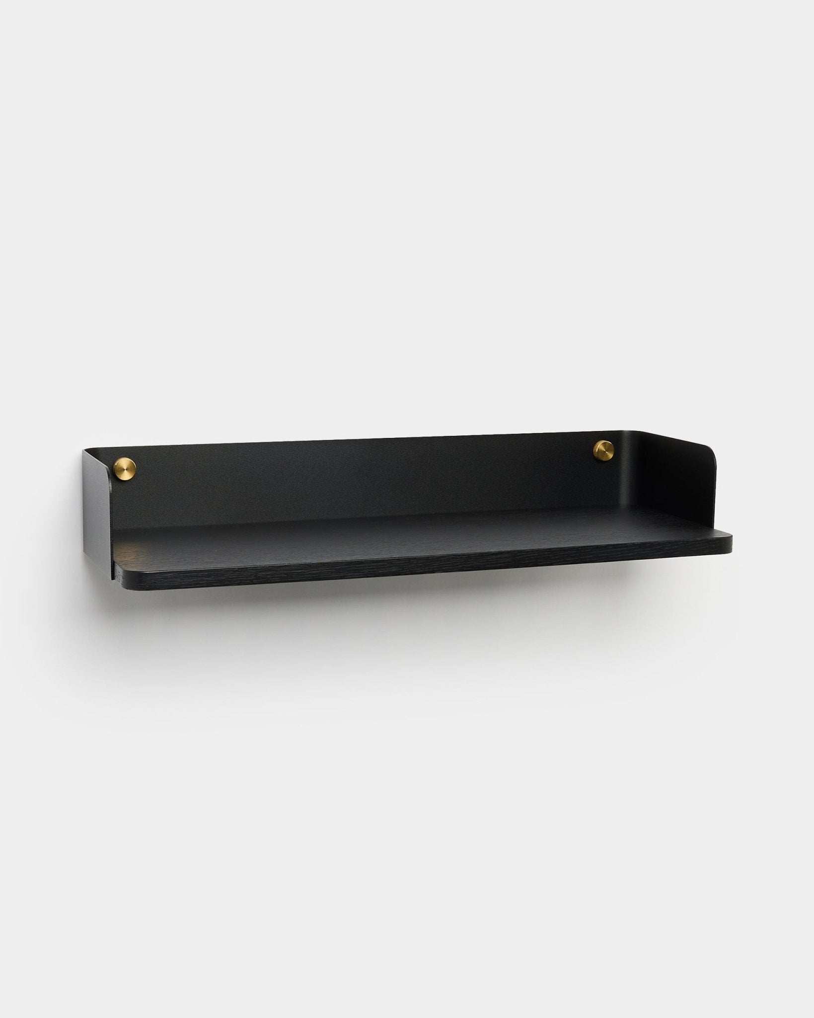 A estante Linn da WoodUpp, uma marca dinamarquesa, apresenta metal black com laterais elevadas e parafusos dourados, pensada para soluções de arrumação modernas.