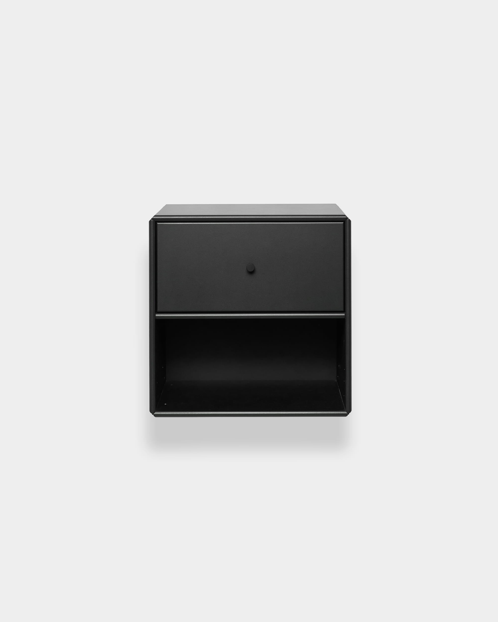 Estante WoodUpp Arka preta com uma gaveta e uma prateleira aberta, destacada num fundo cinzento claro. Design minimalista nórdico.