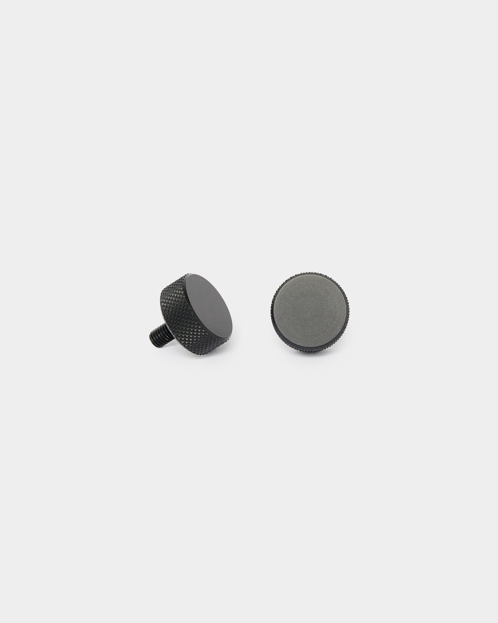 Dois parafusos WoodUpp Finger black (2 unid., M5x10 mm, 20x8,8), apresentados na vertical e deitados de lado sobre um fundo branco simples, para instalação de Akupanel.