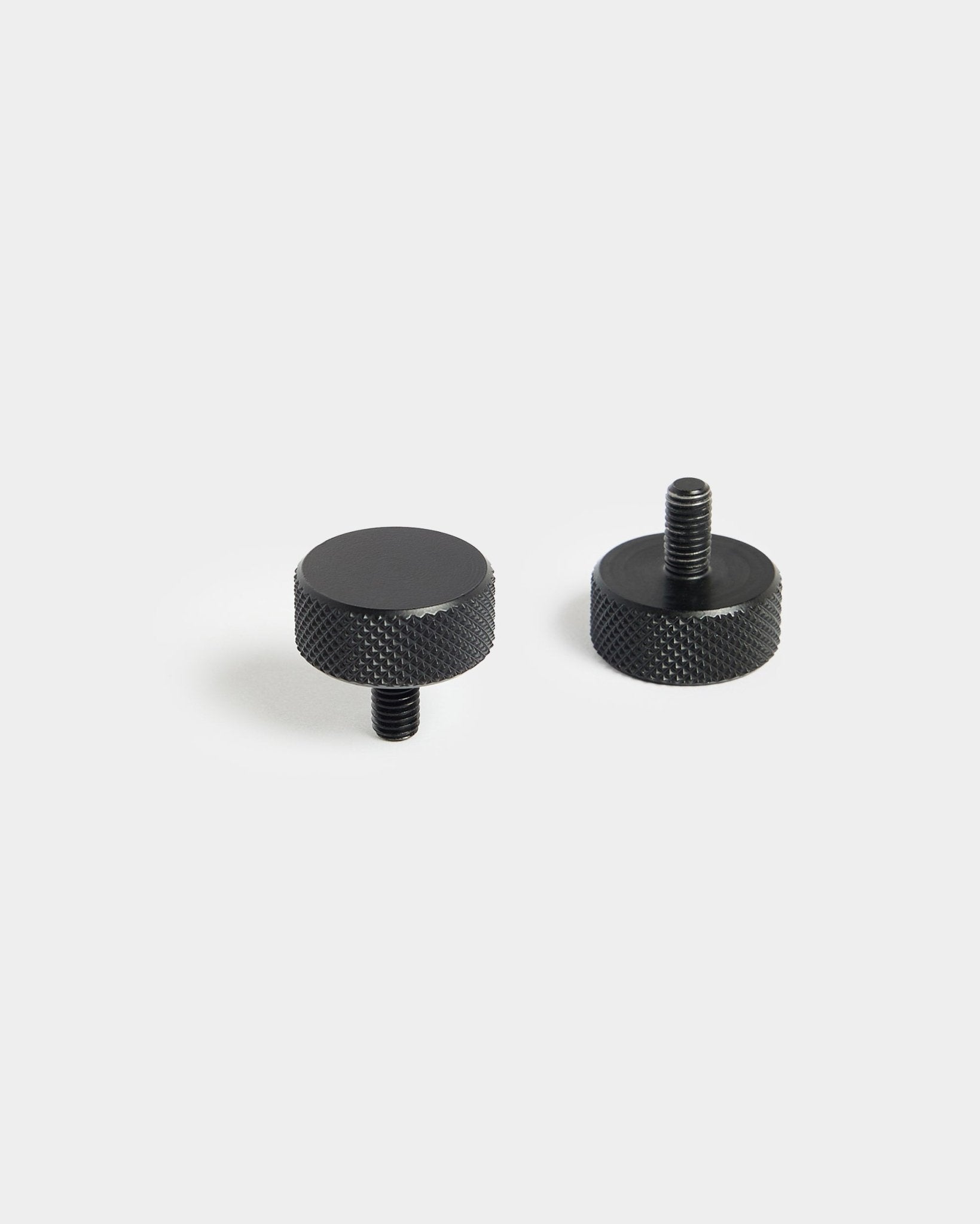 Par de parafusos WoodUpp Finger black (M5x10 mm, 20x8,8) com bordos serrilhados, concebidos para utilização com acessórios Painel acústico, sobre um fundo branco simples.