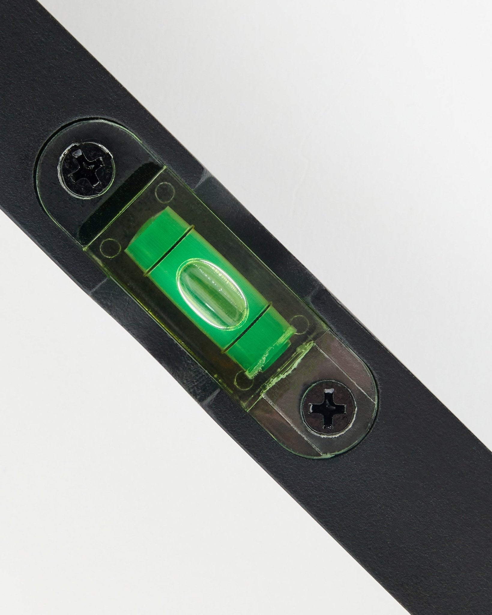 Plano aproximado de um nível de bolha WoodUpp black (15 x 3,2 cm) com ampola verde, usado para a instalação precisa de painéis acústicos.