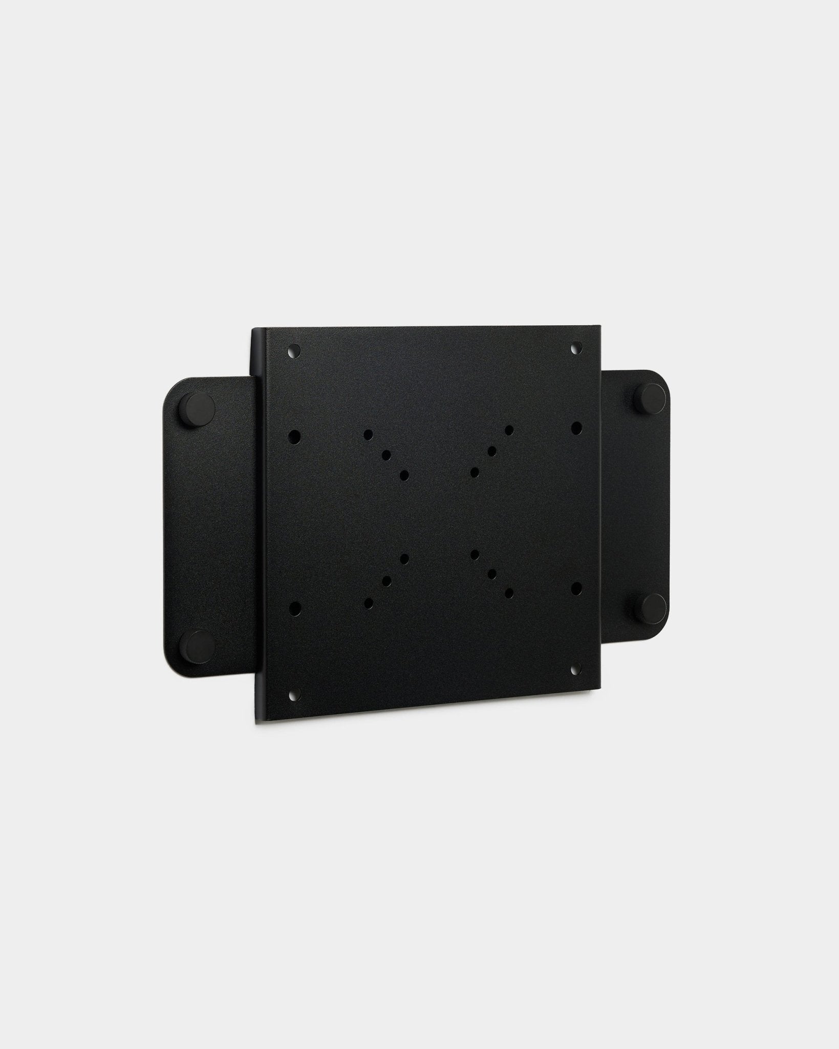 O Fjell | TV Mount (small) da WoodUpp, um suporte metálico black com vários furos para parafusos e fecho magnético, apresentado sobre um fundo branco.