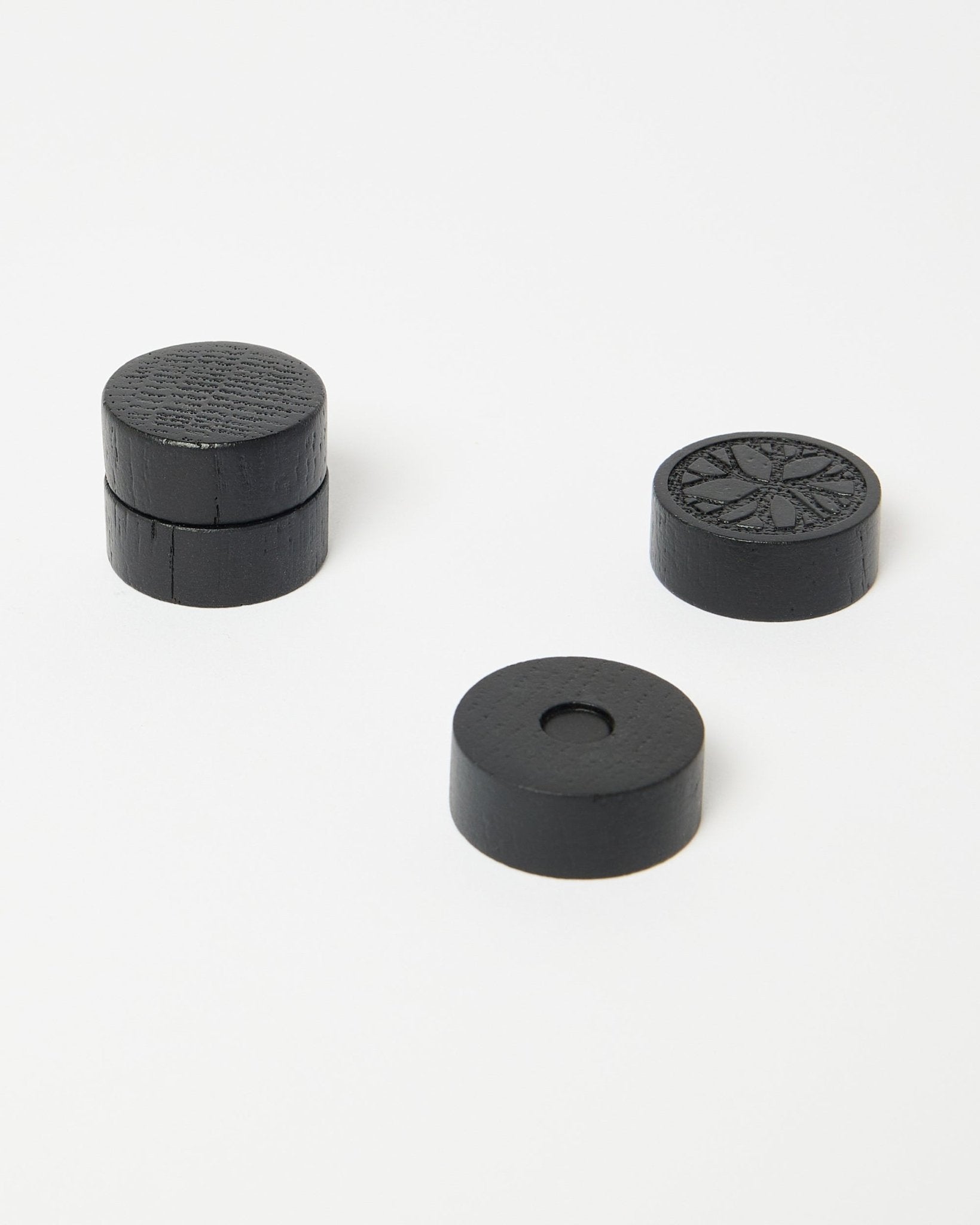 Conjunto de quatro ímanes black oak Norr da WoodUpp, parte da coleção de acessórios CREATE, colocados de forma cuidada sobre uma superfície branca limpa.