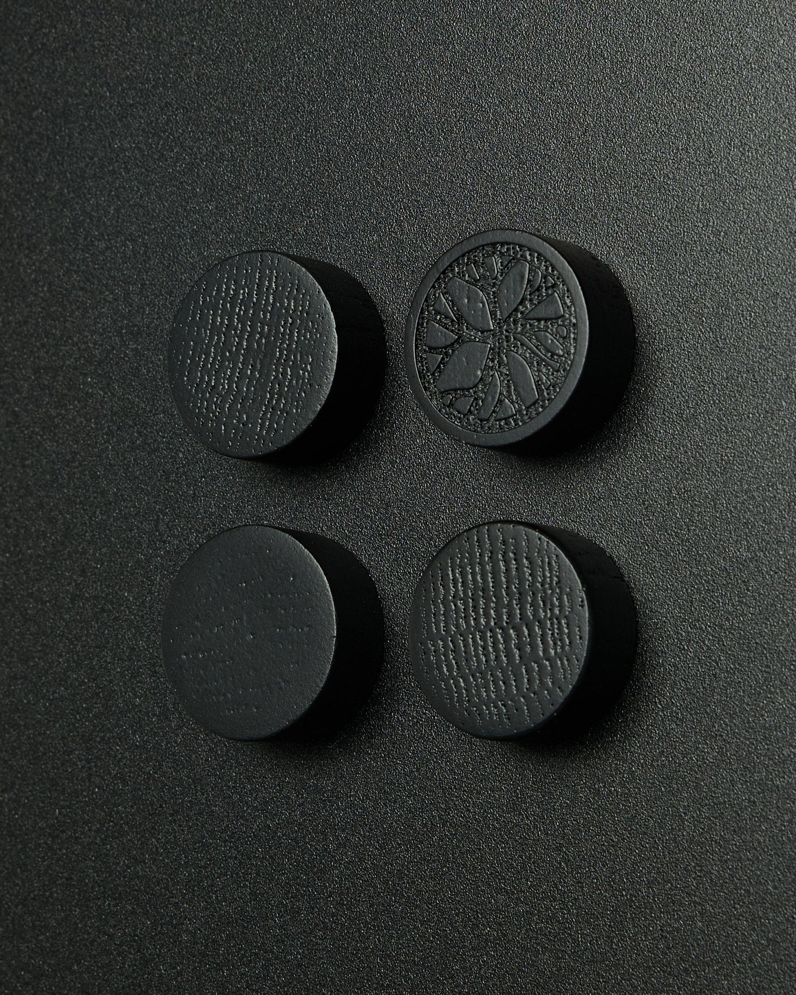 Conjunto de 4 ímanes redondos black oak da WoodUpp, concebidos para o quadro magnético Norr. Acabamento mate com uma subtil textura de madeira. Adequados como acessórios Akupanel.