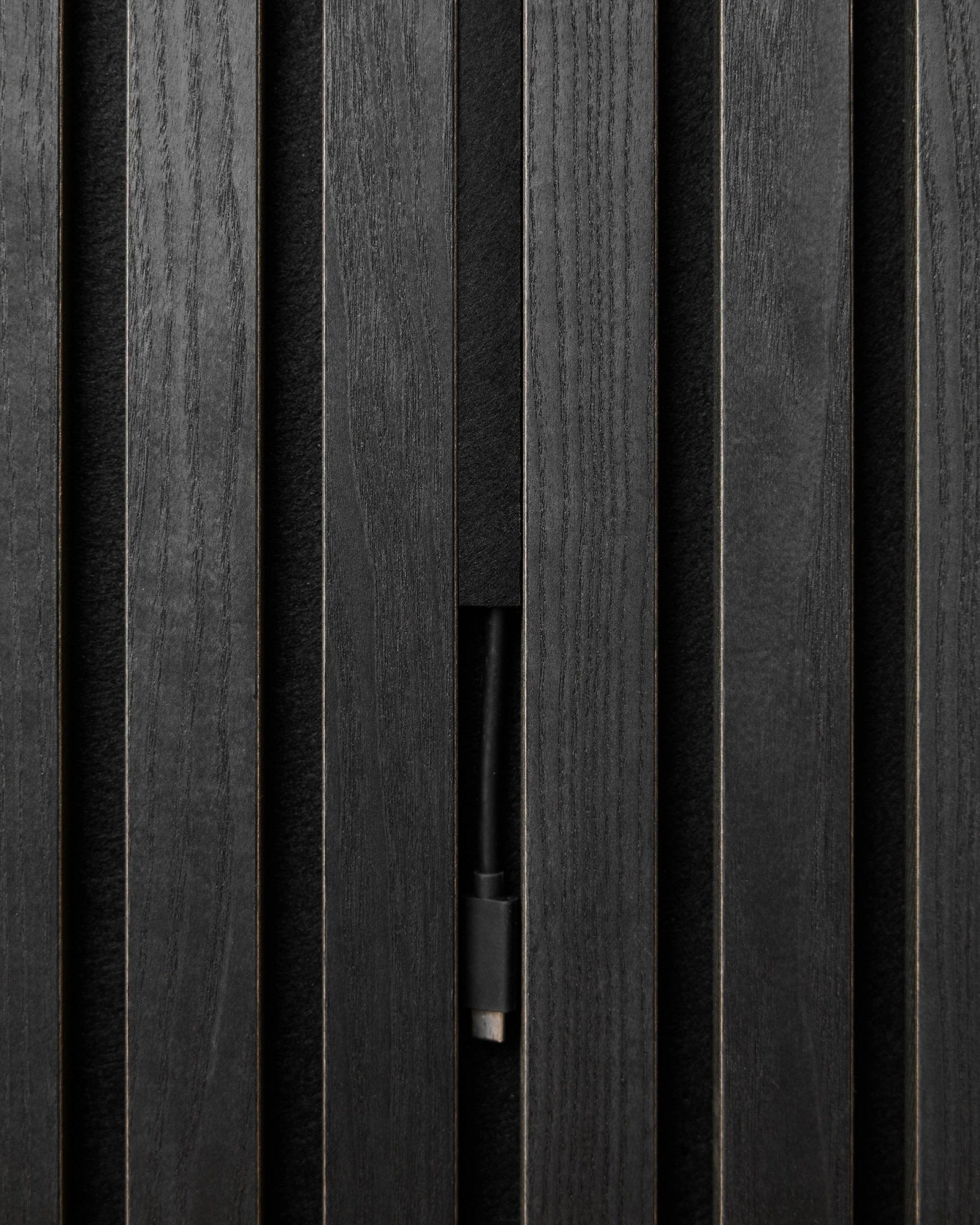 As Black WoodUpp Pop-on Cable Covers (3 unid.) ocultam os cabos de forma discreta por trás dos painéis acústicos de madeira Akupanel, mantendo um visual nórdico limpo e contínuo.
