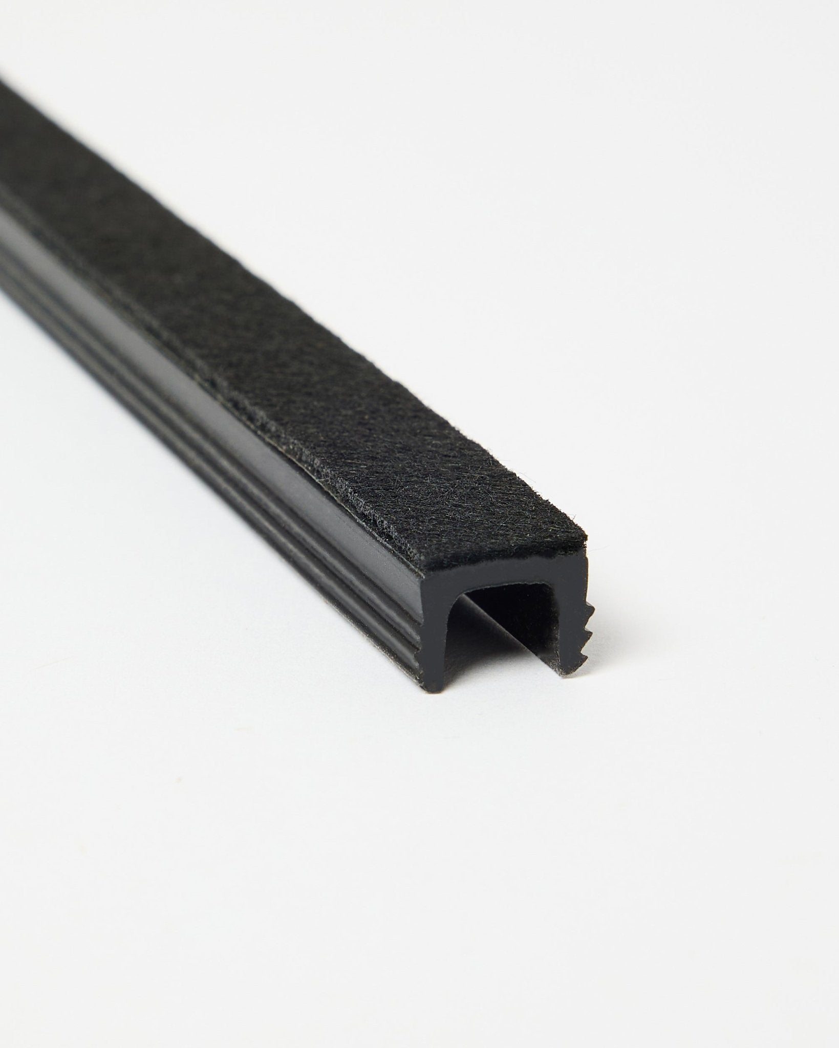 Três black Dupps Pop-on Cable Covers da WoodUpp, apresentadas em ângulo sobre um fundo branco para mostrar a sua forma e acabamento. Acessórios para sistemas Akupanel.