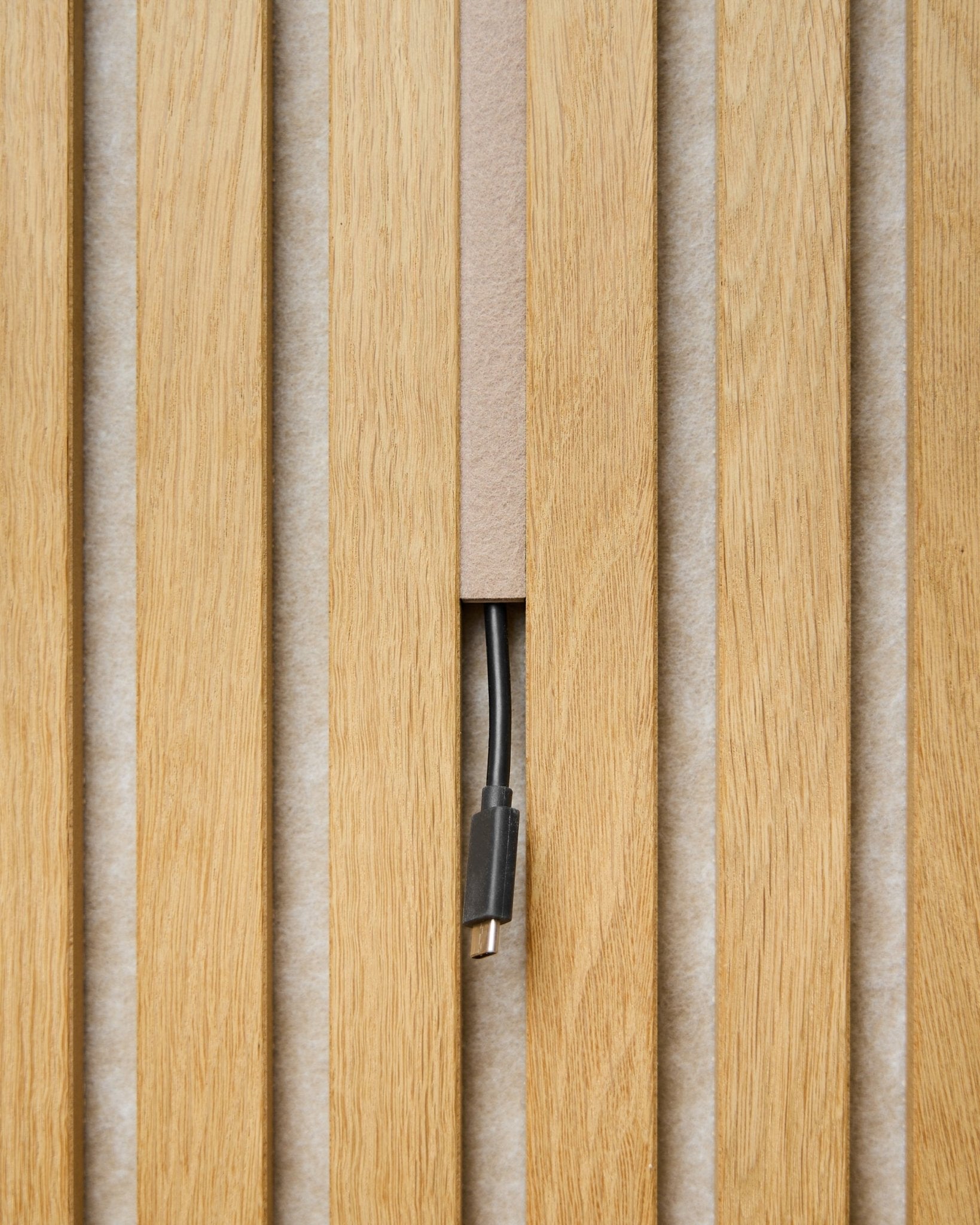 A Dupps Pop-on Cable Cover (beige, conjunto de 3) da WoodUpp oculta os cabos entre as ripas Painel acústico, deixando apenas o conector visível para um acabamento mais clean.