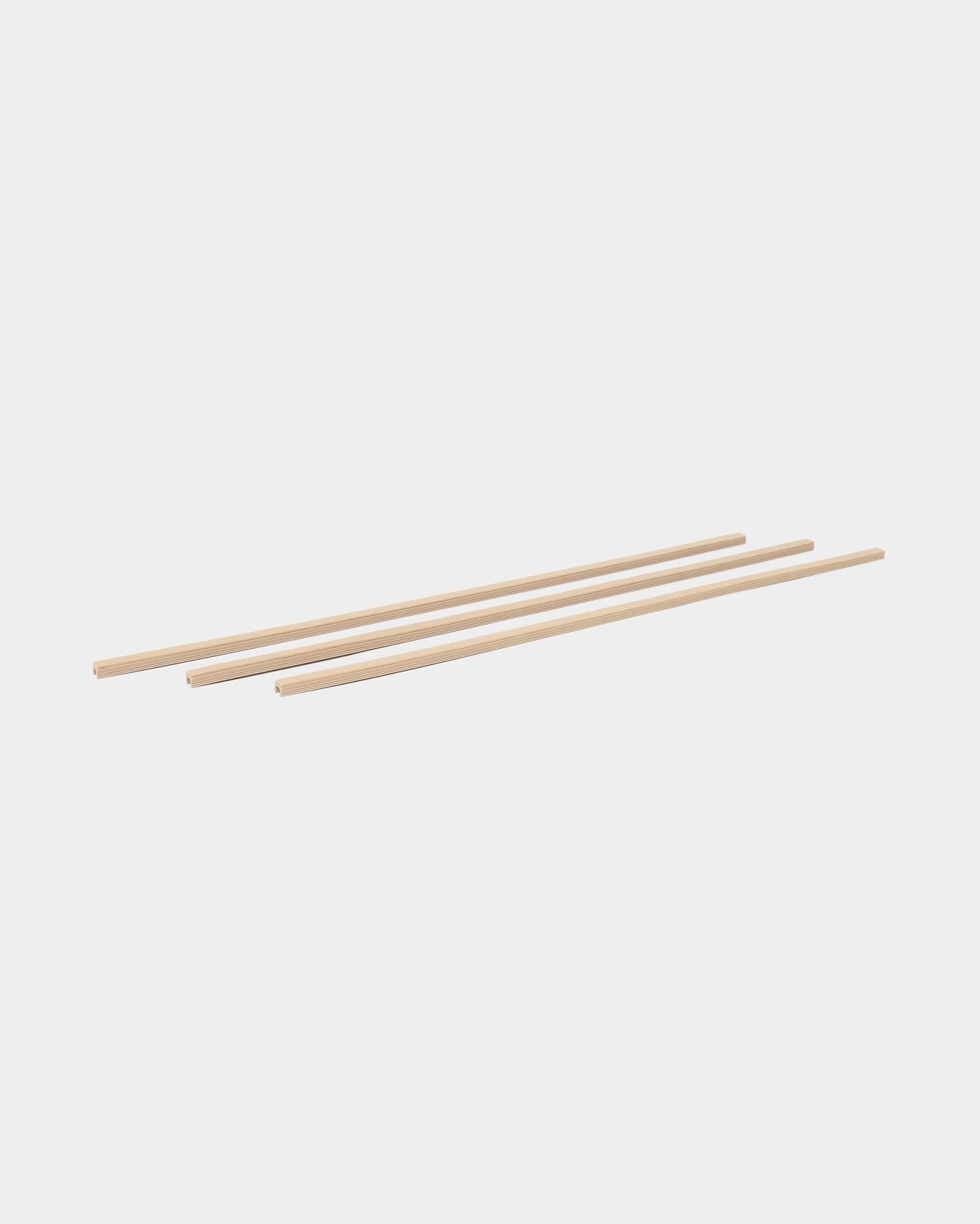 Três beige Dupps Pop-on Cable Covers (3 peças) da WoodUpp, da coleção de acessórios CREATE, dispostas em paralelo sobre um fundo branco.