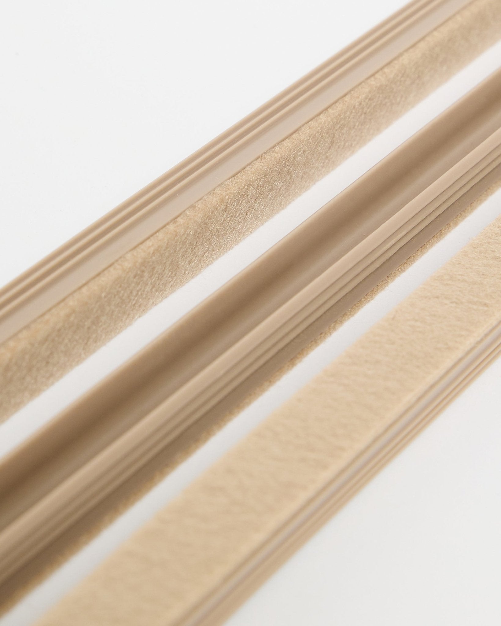 Beige Pop-on Cable Covers da WoodUpp Dupps (pack de 3), com textura em feltro e verso adesivo, apresentadas sobre uma superfície branca para organizar os cabos.
