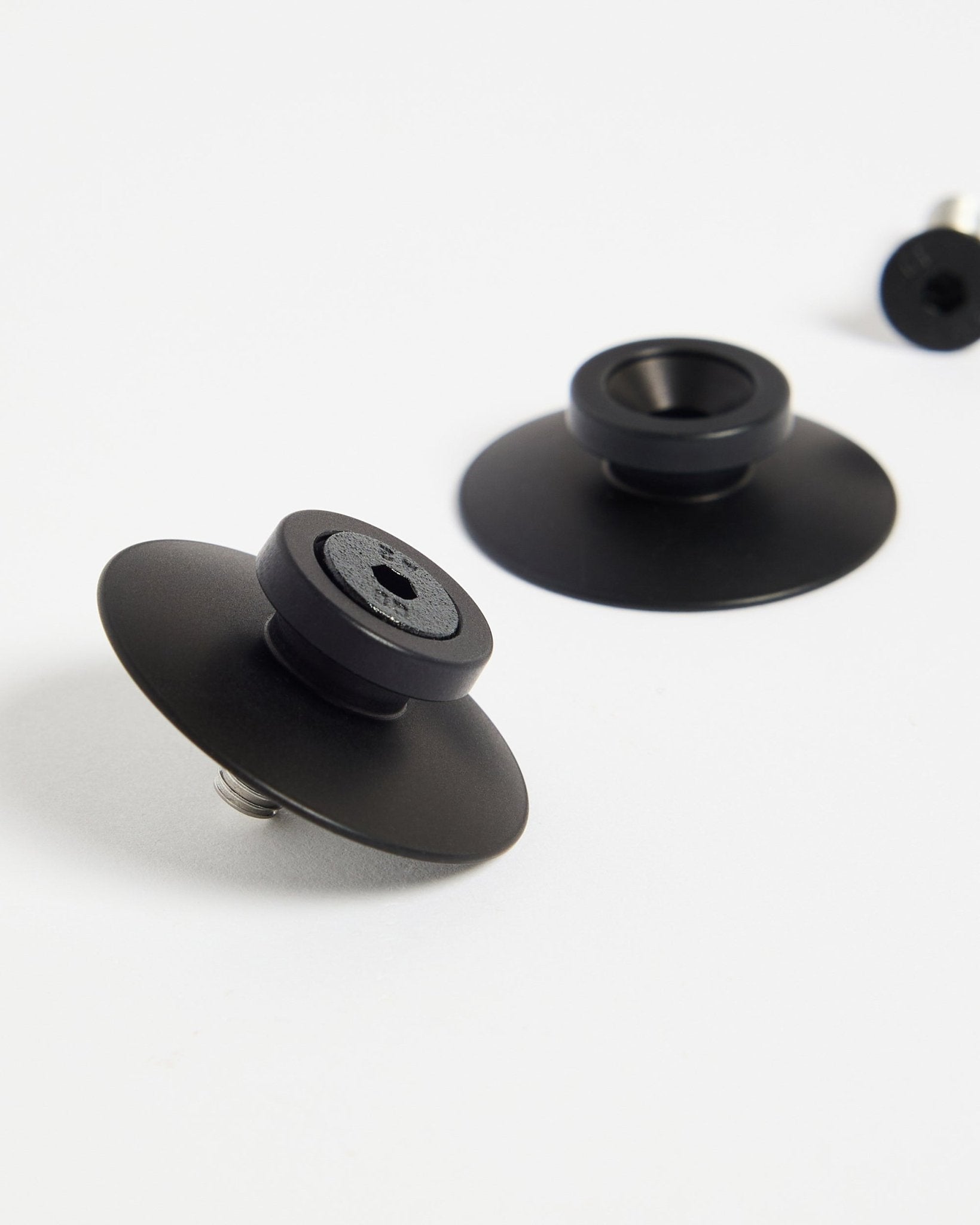 Dois fixadores WoodUpp Dupps em alumínio black (2 unid.) sobre uma superfície branca, concebidos para montar painéis acústicos ou divisórias de forma segura.