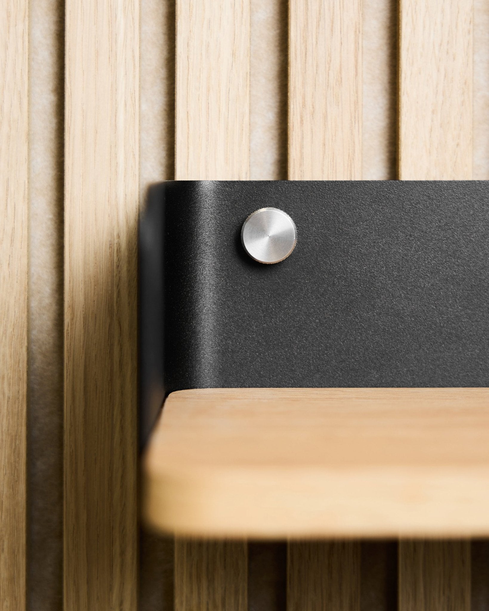 Grande plano de uma prateleira em madeira clara com suporte metálico black, montada com parafusos de aperto manual WoodUpp (M5x10 mm, aço inoxidável steel), combinada com Nordic Painel acústico.