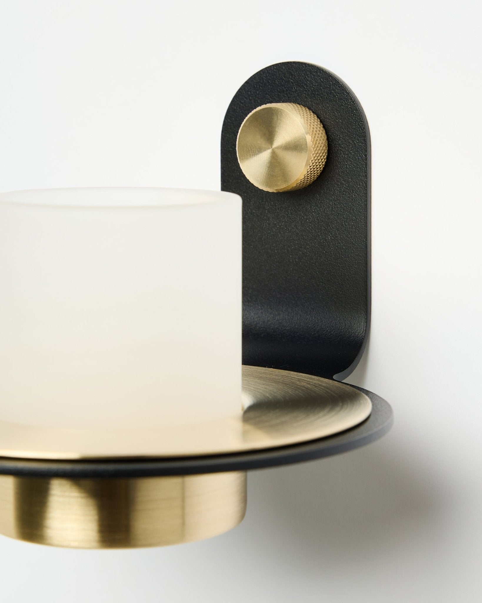O Suporte para Velas Norr da WoodUpp, em black e brass, apresentado montado com velas LED num Painel acústico branco.