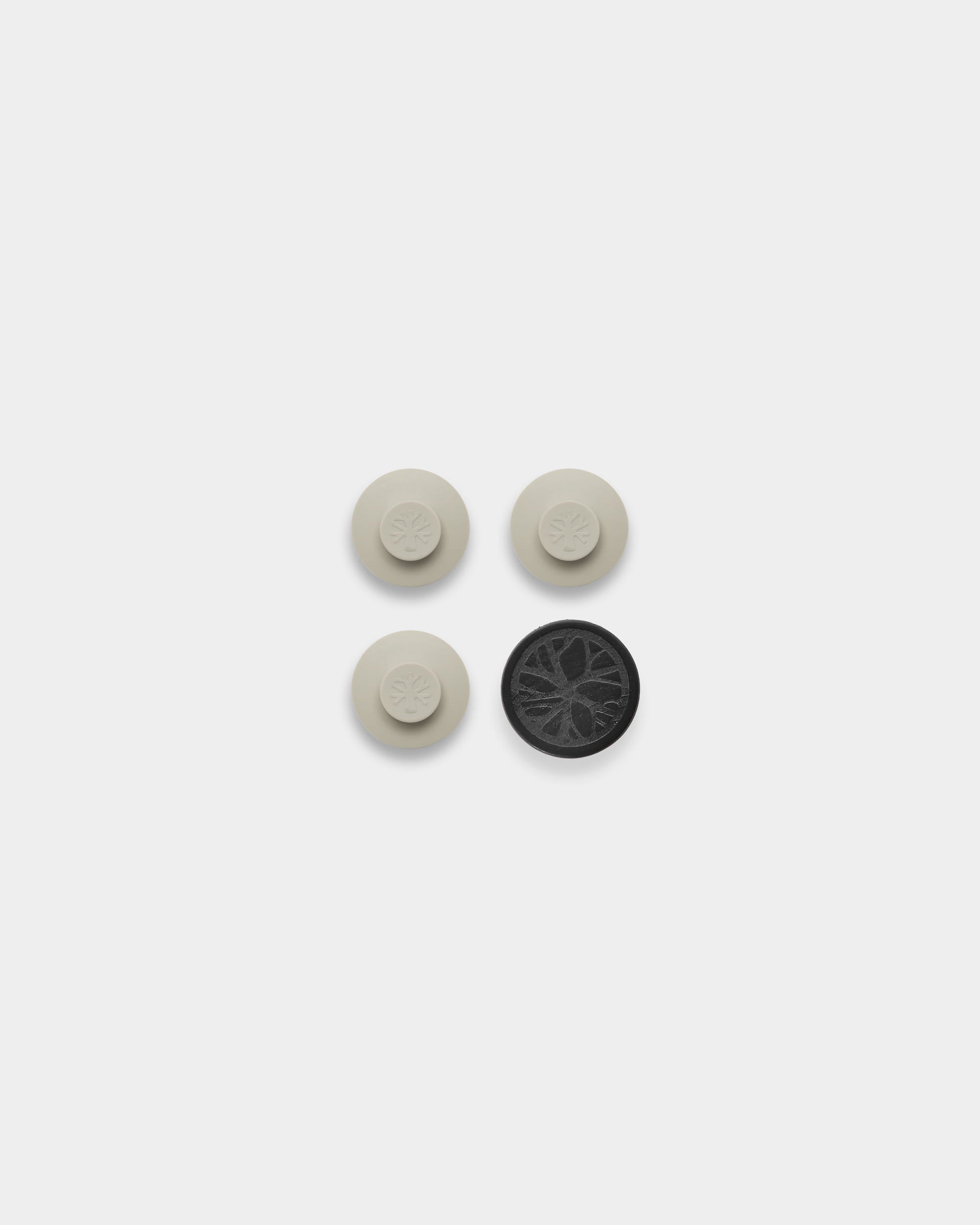 Conjunto WoodUpp Dupps: três acessórios acústicos redondos em bege com padrões circulares e uma ferramenta, dispostos para montagem na parede sobre um fundo branco.