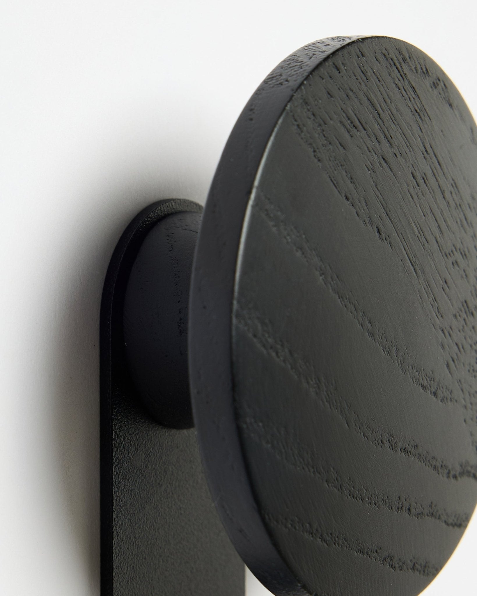 Grande plano do cabide WoodUpp Linn | Vertical em Black Oak, destacando o veio detalhado da madeira sobre um fundo branco Akupanel Painel acústico.