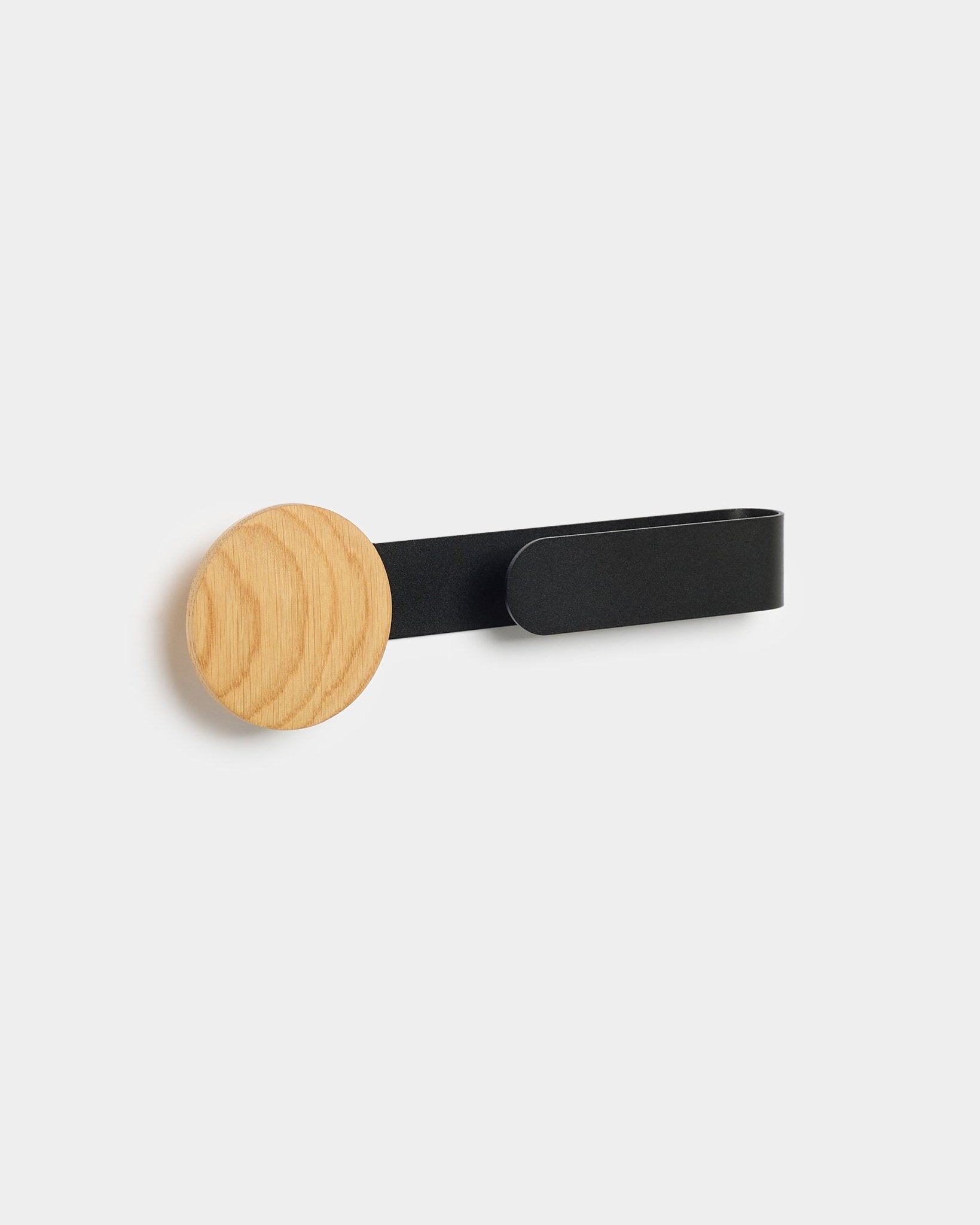 Linn Horizontal Hanger da WoodUpp com um botão em natural oak e braço metálico em black, concebido para complementar o seu Akupanel Painel acústico.