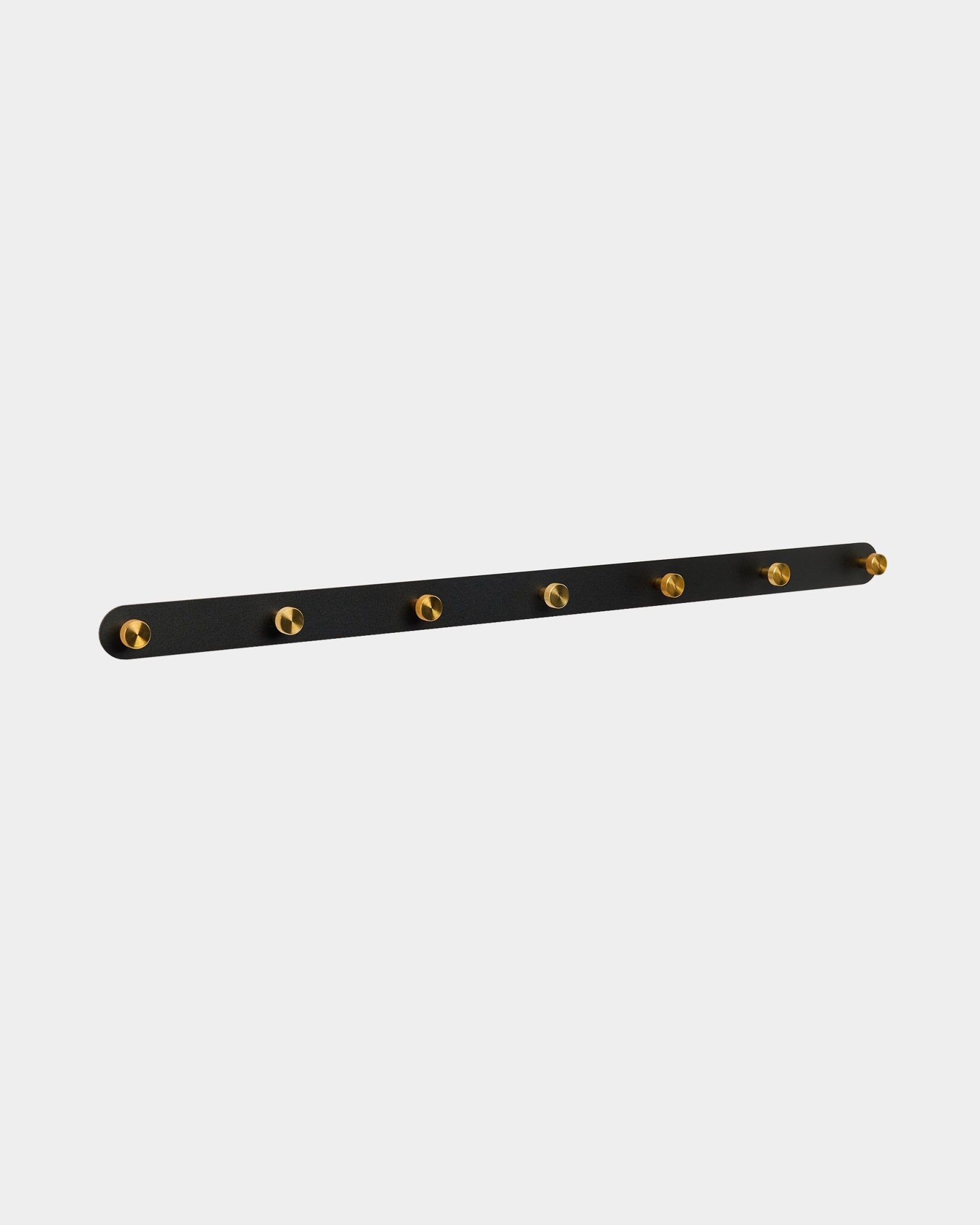 Cabide de parede Norr da WoodUpp com 7 ganchos brass numa base black Painel acústico, concebido como organizador de corredor compatível com as coleções Akupanel.