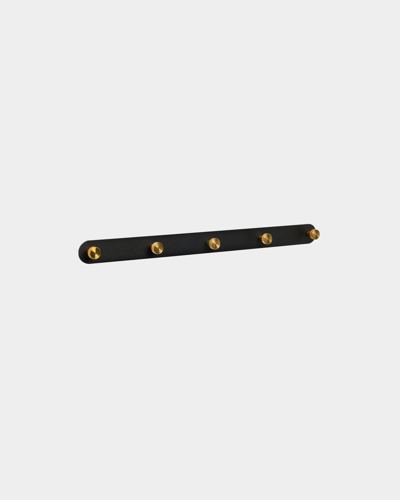 Cabide de parede WoodUpp Norr em black e brass, com 5 ganchos steel, montado na parede, apresentado sobre um fundo branco liso.