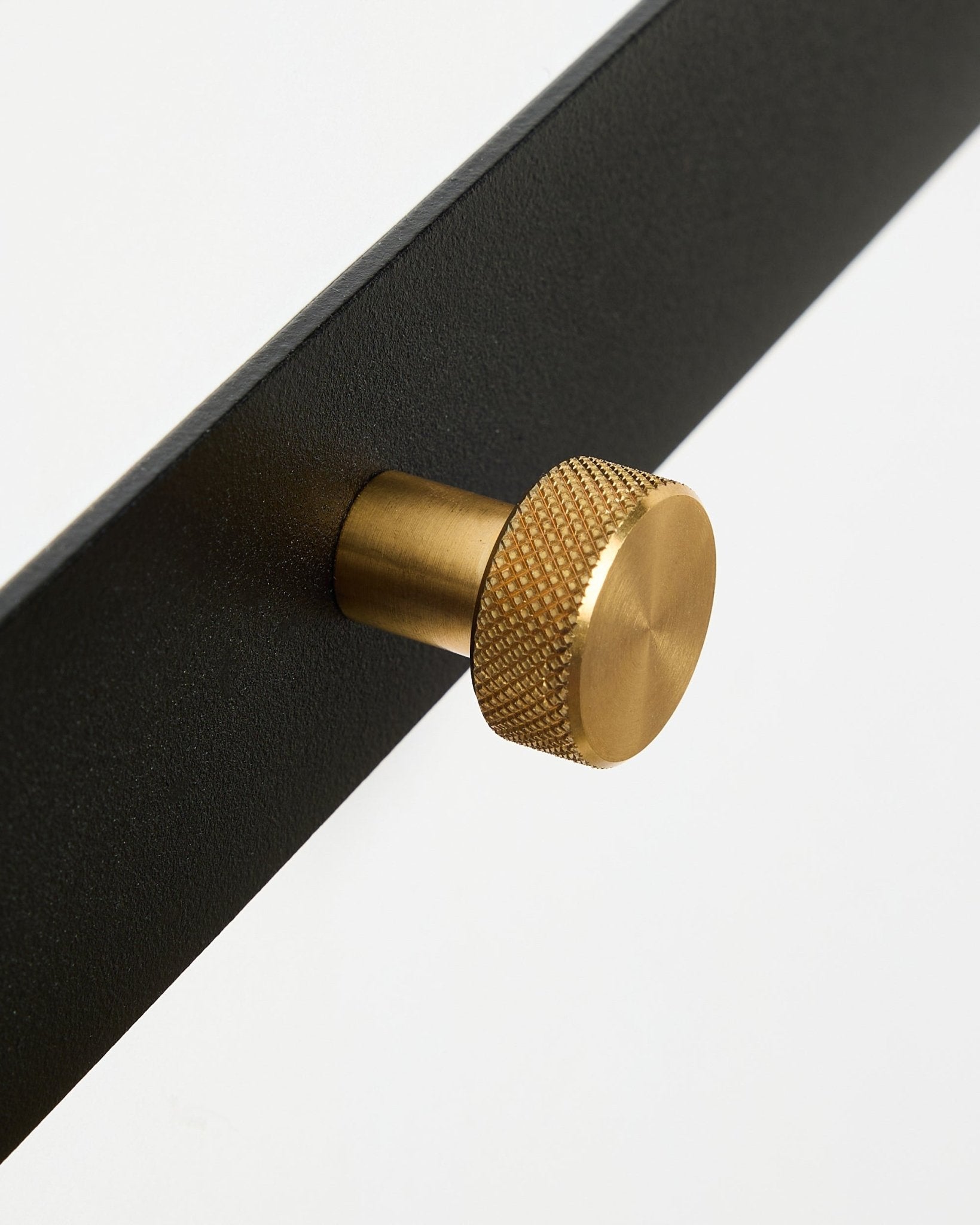 Plano aproximado do cabide de parede Norr X5 da WoodUpp, com acabamento em black lacado a pó steel e botões redondos texturados em brass, sobre um fundo branco.