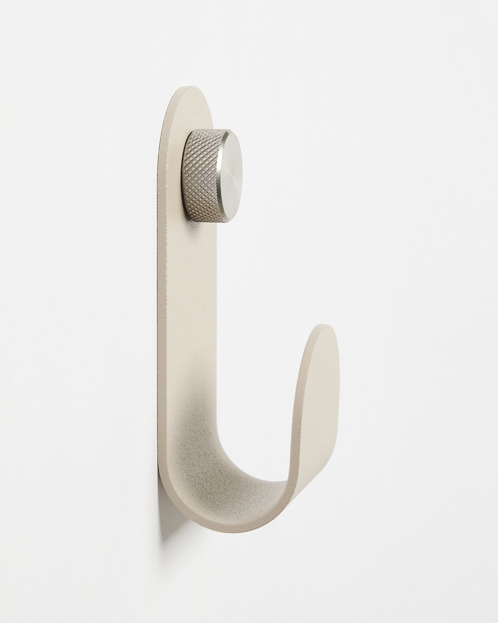 O Norr | Single Hanger em Beige da WoodUpp, um acessório de parede minimalista com botão prateado, concebido para complementar painéis acústicos de madeira Akupanel.
