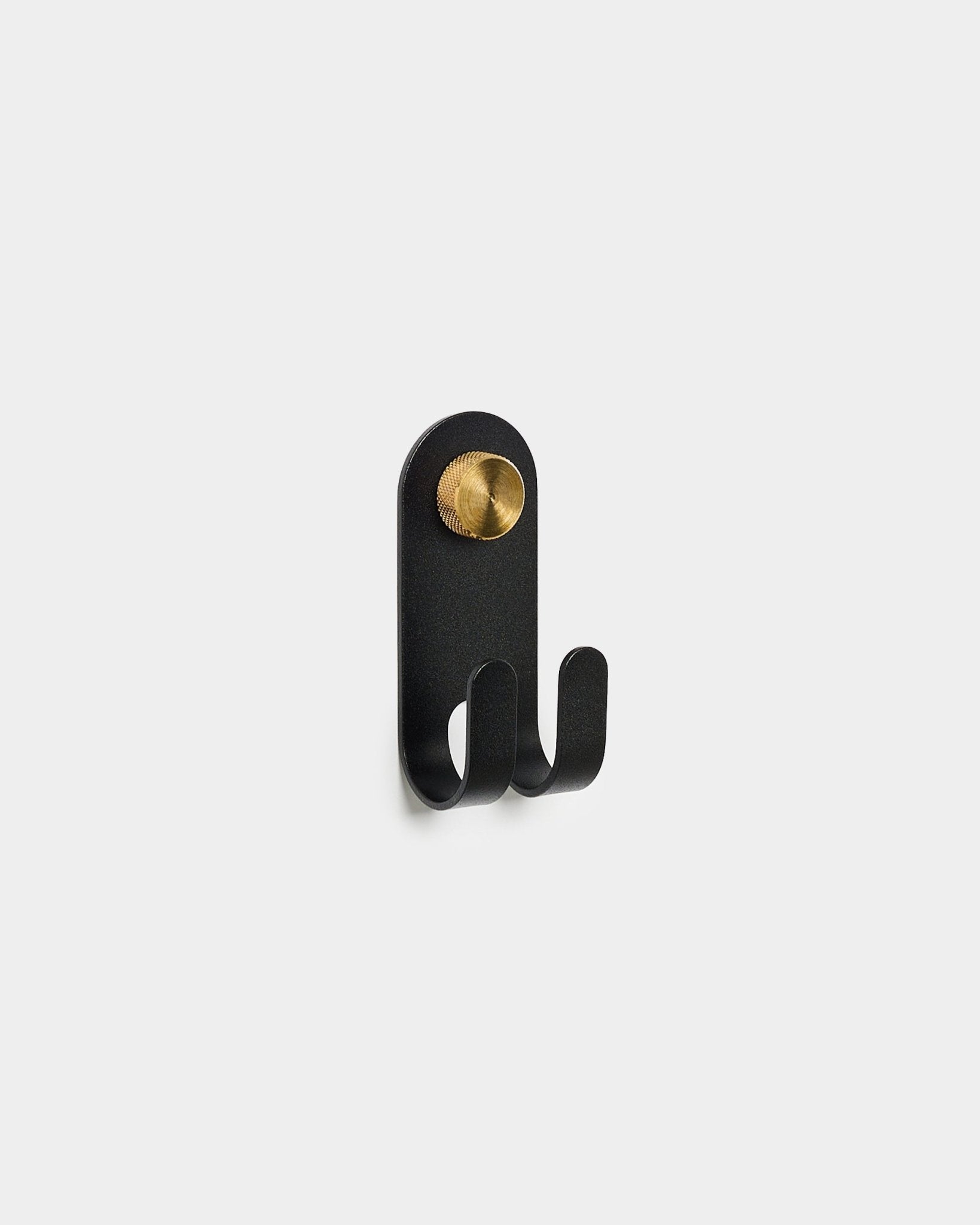 WoodUpp Norr Double Hanger em black, com dois ganchos e um detalhe redondo em brass, apresentado sobre um fundo branco liso.