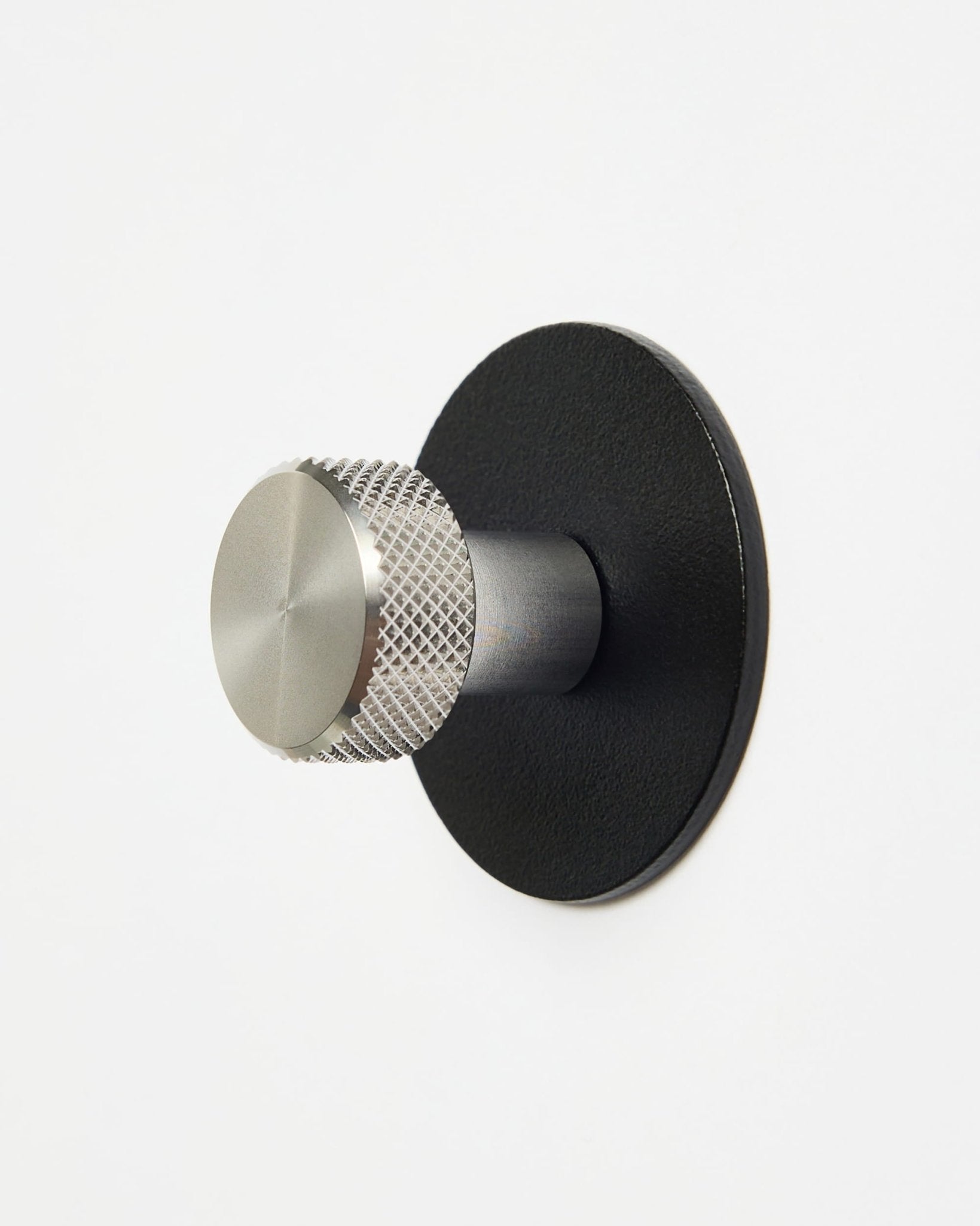 WoodUpp Norr | Coat Hook X1 em black e steel inoxidável, instalado numa parede branca lisa, concebido como acessório da coleção CREATE para sistemas Akupanel.